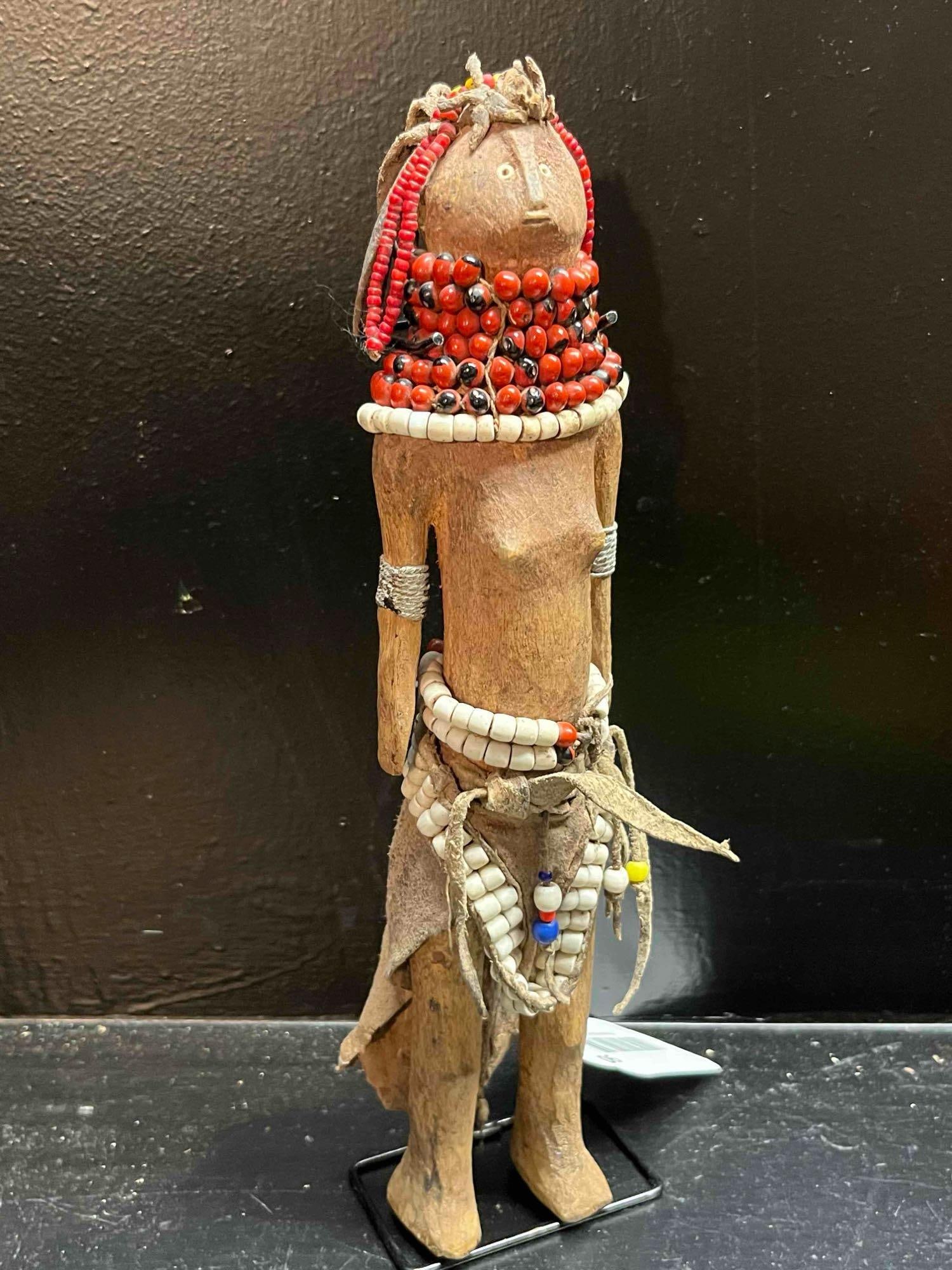 Turkana Beaded Wood & Leather Ikoku: An African hand-carved wooden female figure, a traditional Turkana Ikoku fertility doll from Kenya. The figure is carved with a cylindrical torso and a stylized head featuring a flattened, disc-like f