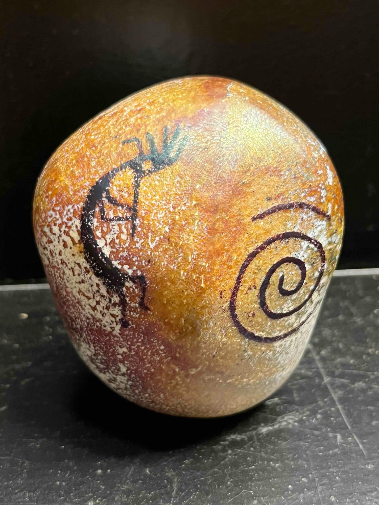 Richard Satava Petroglyph Paperweight: A Richard Satava art glass paperweight from the Petroglyph series, fashioned from blown glass with an organic, rounded form. The exterior is finished with a textured, matte surface in mottled ocher, r
