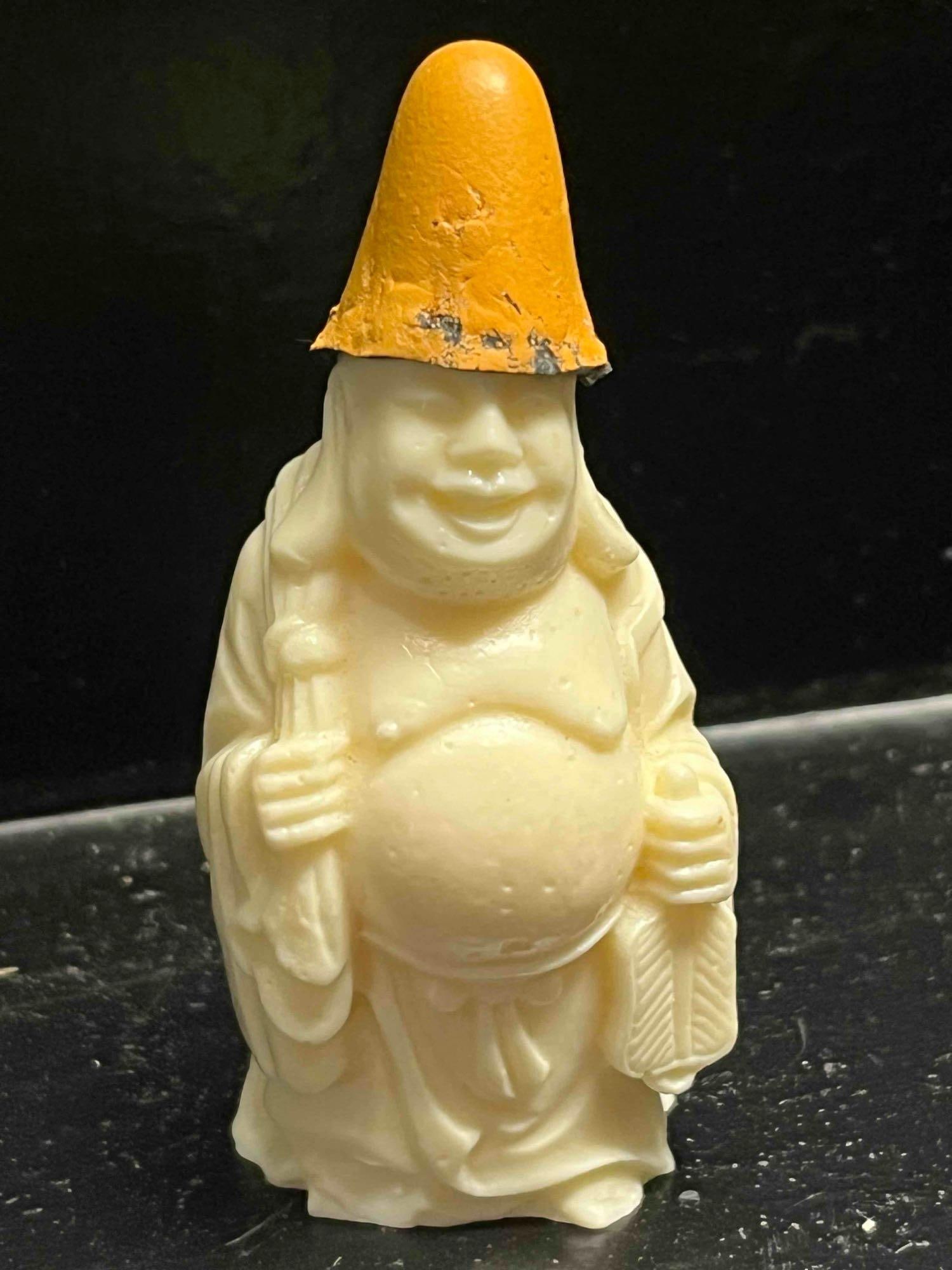 Chinese Resin Hotei Figurine w/ Hat: A miniature standing figurine of Hotei, the Laughing Buddha, crafted from an off-white cast resin intended to simulate the appearance of aged ivory or bone. The figure is depicted in a traditional sta