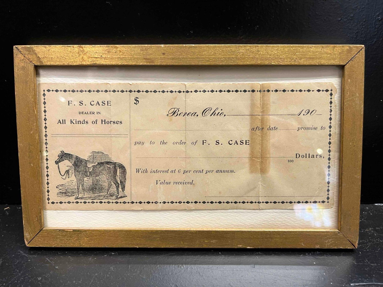 F. S. Case Horse Dealer Promissory Note: A framed unissued promissory note for F. S. Case, identified as a Dealer in All Kinds of Horses based in Berea, Ohio. The document is printed on paper featuring a decorative diamond-patterned border. 