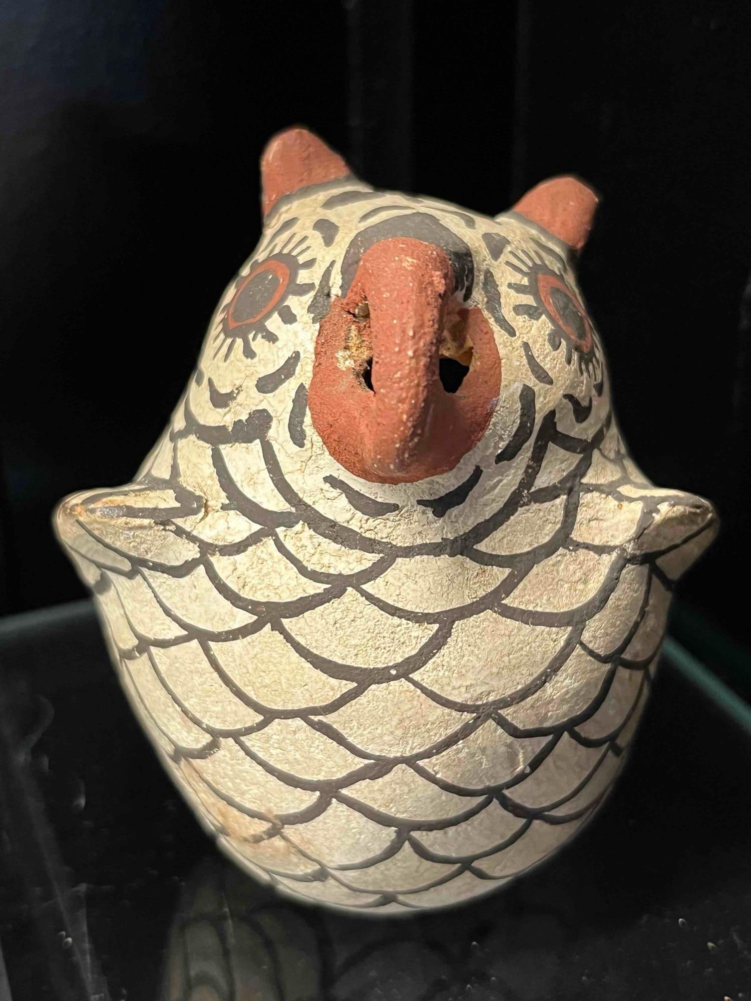 Zuni Pueblo Polychrome Owl Whistle: A hand-coiled and painted ceramic owl figurine of Zuni Pueblo origin, functioning as a whistle with a hollow protruding beak that contains two circular apertures. The exterior is finished with a cream
