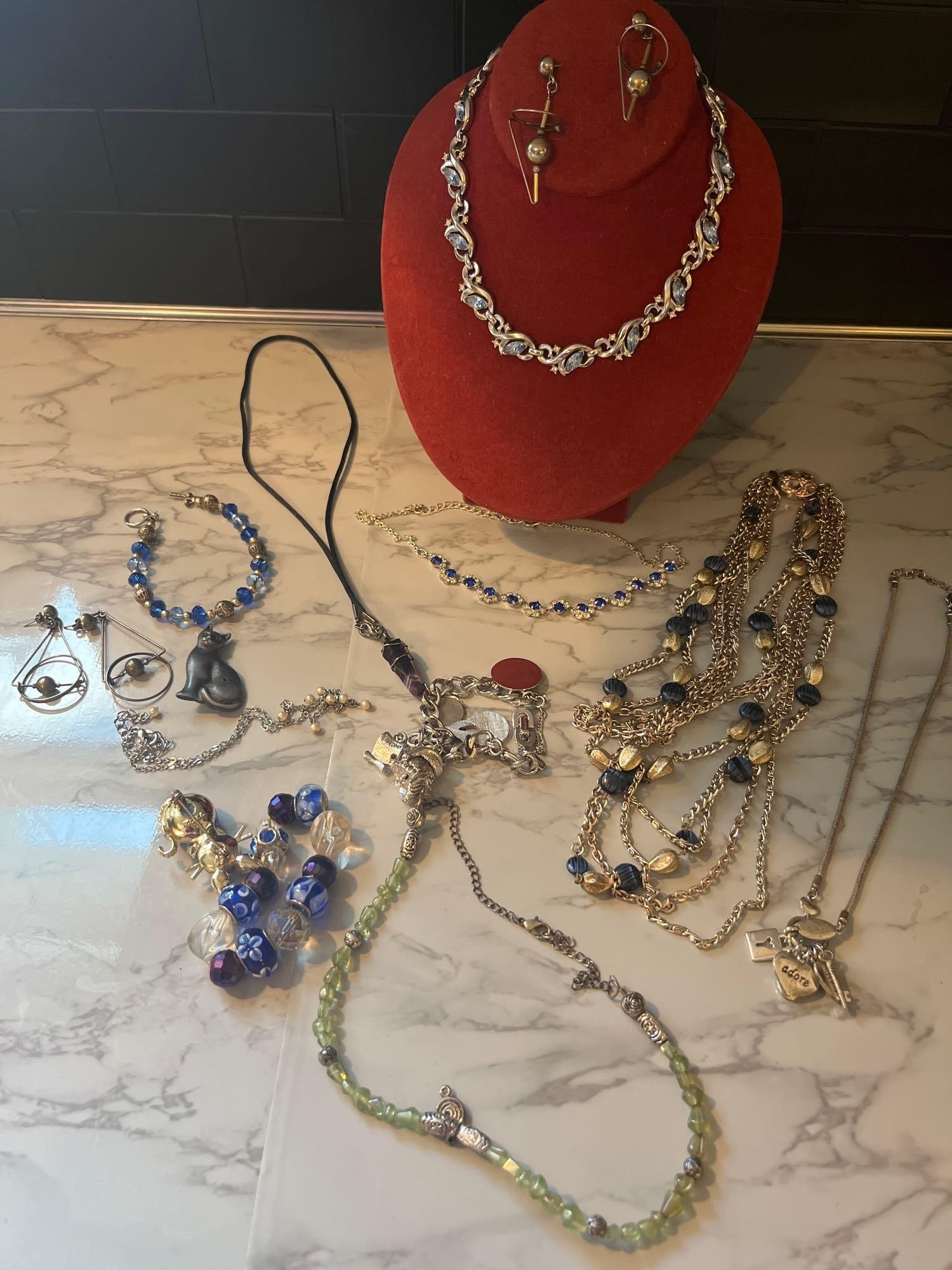 Monet & Costume Jewelry, 15 Pcs: This lot consists of a collection of 15 pieces of and contemporary jewelry, comprising necklaces, bracelets, earrings, and brooches. The grouping includes nine necklaces featuring various styles: a si