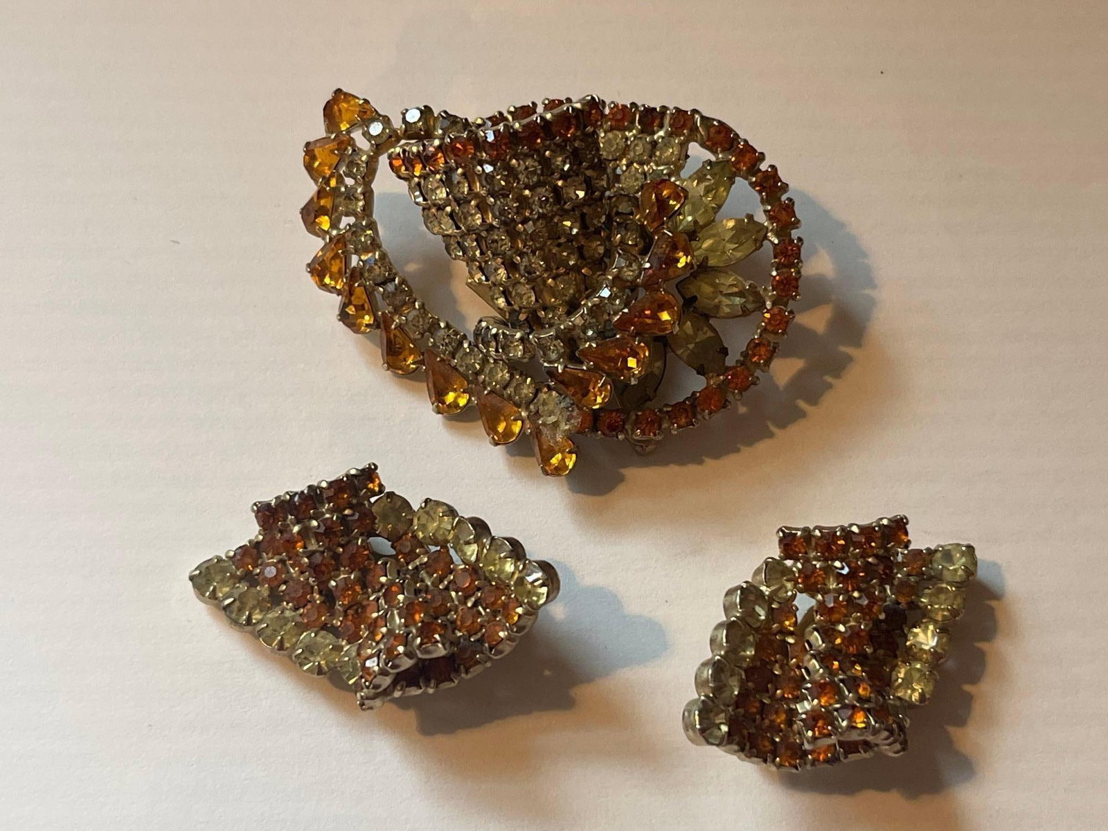 Figural Teacup Brooch & Earring Set: A three-piece costume jewelry set in a gold-tone base metal, consisting of a figural brooch and a pair of matching clip-on earrings. The brooch is designed in three dimensions to depict a teacup resti