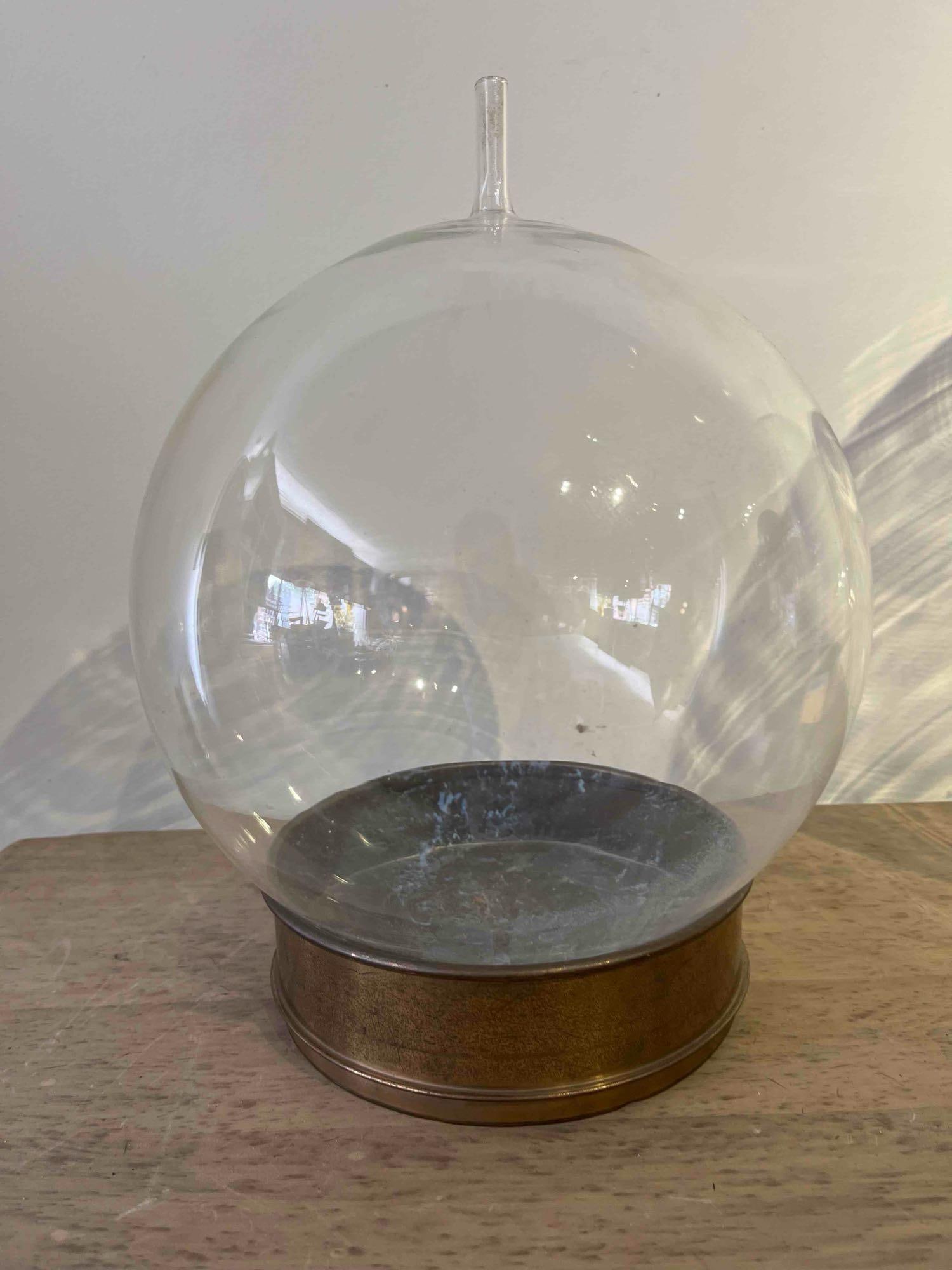 W.S. Tyler Industrial Sieve & Globe: A industrial assembly consisting of a large, clear glass spherical vessel seated within a brass testing sieve base. The glass globe is designed with a single vertical port or neck at the top apex. The