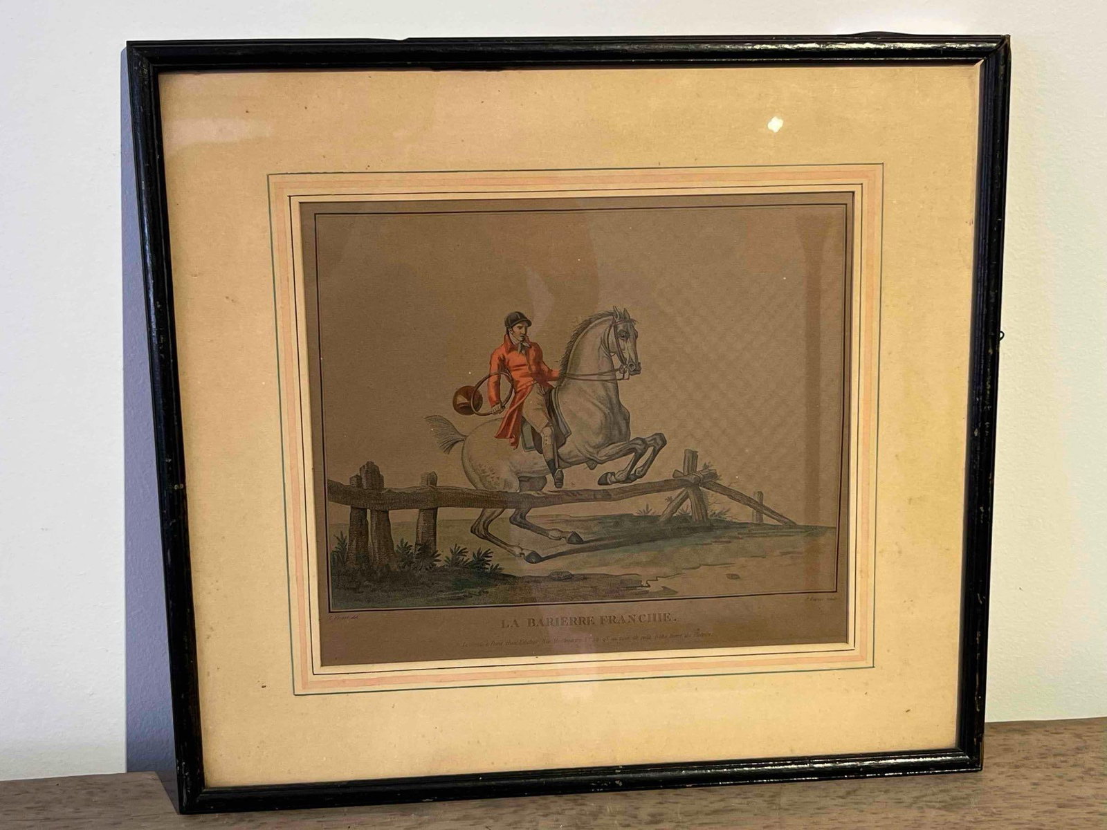 Carle Vernet La Barierre Franchie Print: This hand-colored stipple engraving and etching is titled LA BARIERRE FRANCHIE. (The Jumped Barrier) and depicts an equestrian scene. The image features a rider wearing a traditional red hunting coat