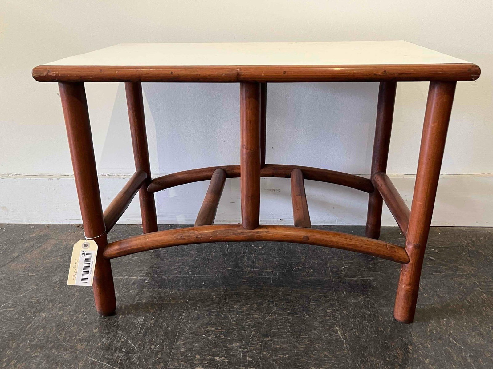Mid-Century Rattan/Laminate Side Table: A mid-century modern side table featuring a structural base constructed from thick, cylindrical wood poles with a reddish-brown stain. The design incorporates a six-leg configuration joined by two