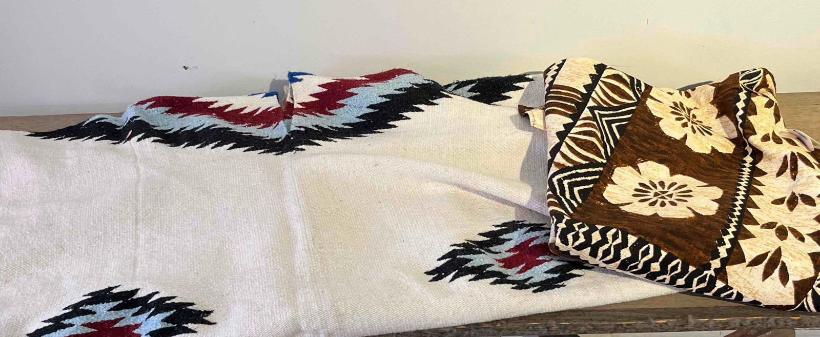 Southwestern Poncho & Polynesian Cloth: This lot features two large decorative textiles. The first is a Chinese-made woven poncho crafted from a heavyweight cream-colored fabric. The design includes four serrated diamond medallions