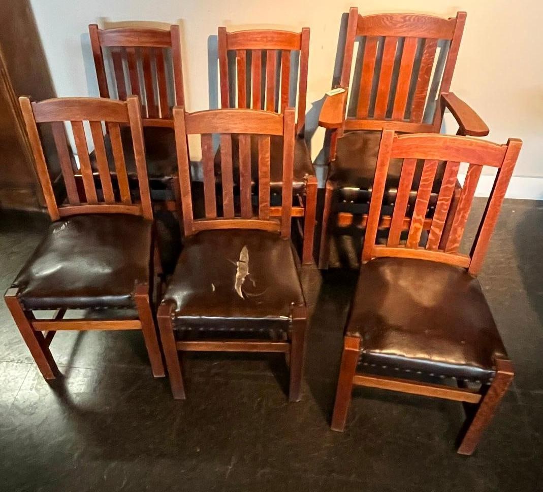 Set 6 Arts & Crafts Mission Oak Chairs: A set of six Arts and Crafts Mission style dining chairs crafted from quarter sawn white oak, comprising one armchair and five side chairs. Each chair features a rectilinear frame with a slightly