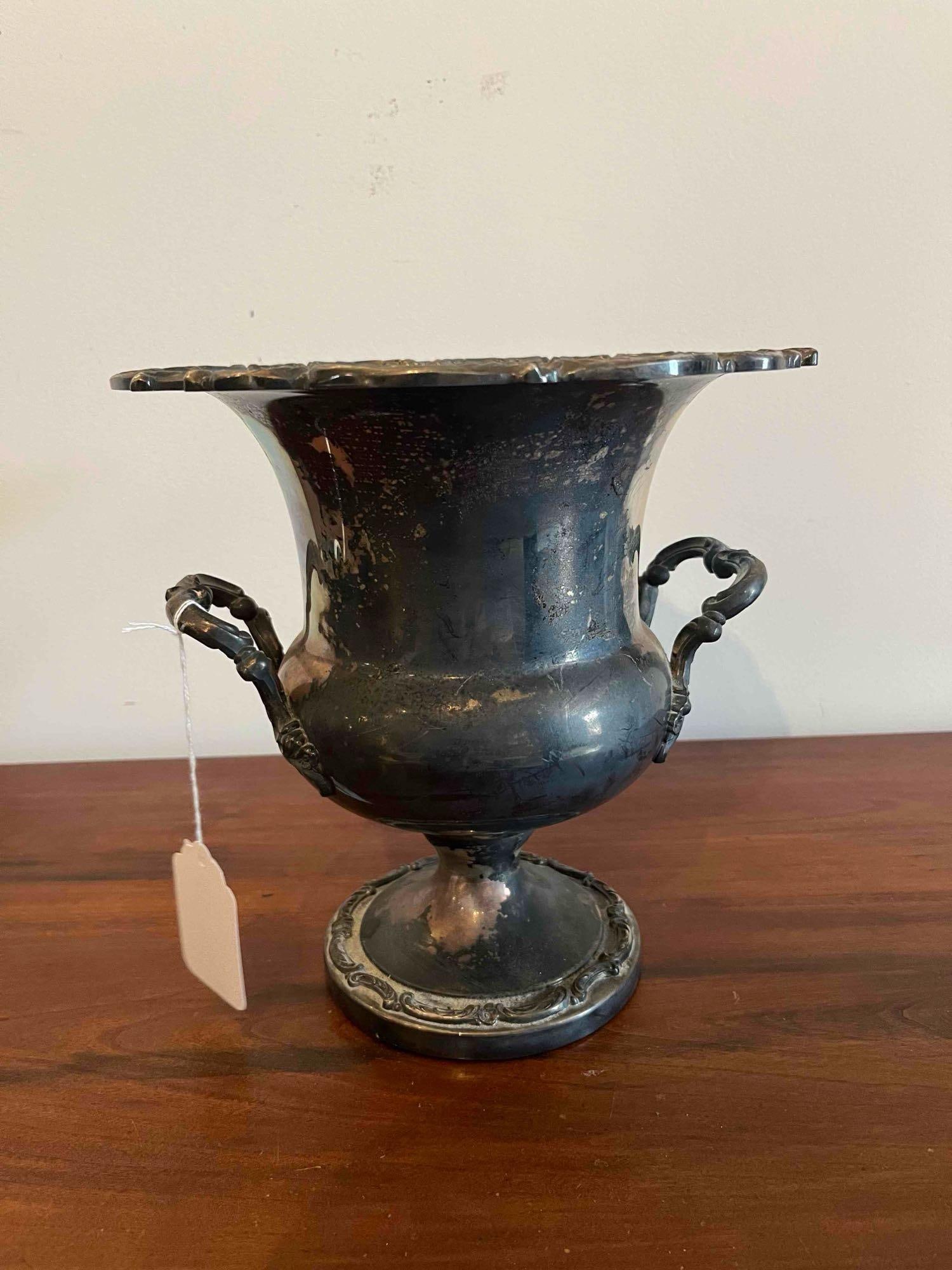 Rococo Revival Silver Plate Wine Cooler: A silver-plated wine cooler or champagne bucket in the Rococo Revival style, featuring a flared, scalloped rim decorated with shell and foliate scroll relief. The urn-form body is flanked by two