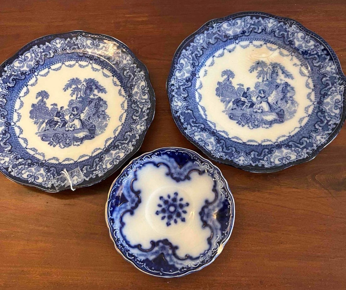 3 N.W.P. Co Flow Blue Watteau Plates: This lot consists of three pieces of underglaze transfer-printed earthenware in a flow blue style, characterized by the intentional blurring of the cobalt pigment into the glaze. Two matching plates