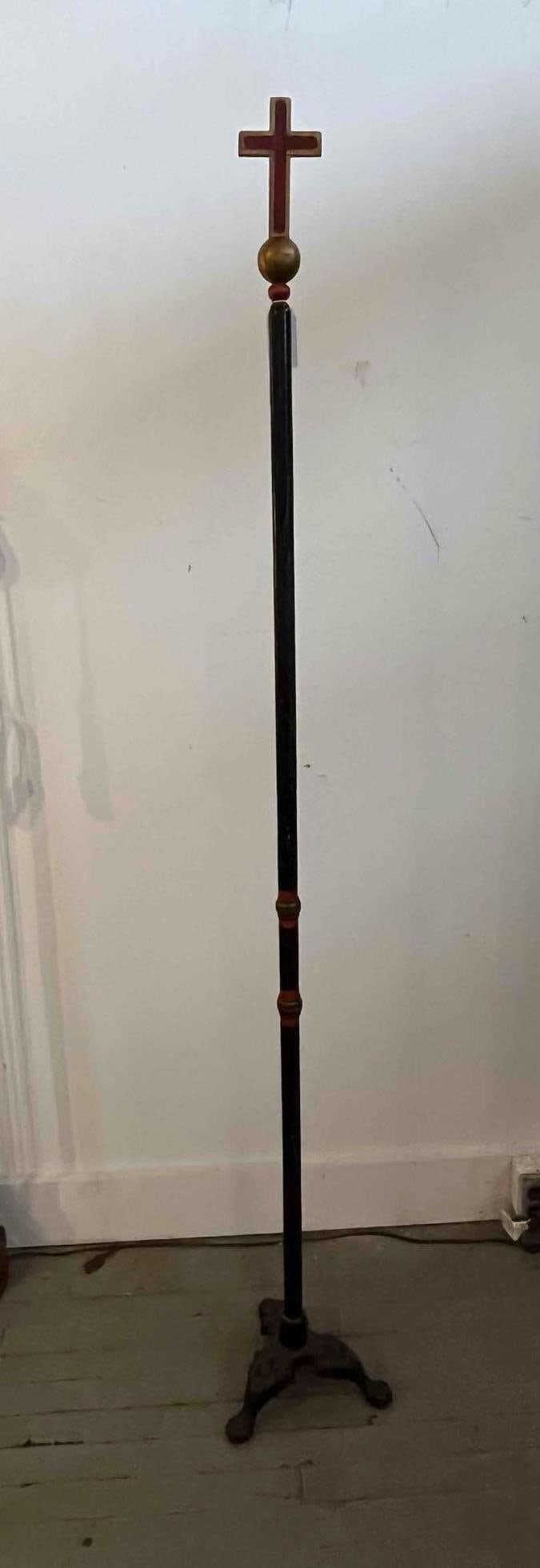 Fraternal Processional Cross, Iron Base: A floor-standing ceremonial staff surmounted by a Latin cross finial. The cross is designed with a recessed red-painted field and gilded borders, resting on a gilded orb. The tall staff is composed of