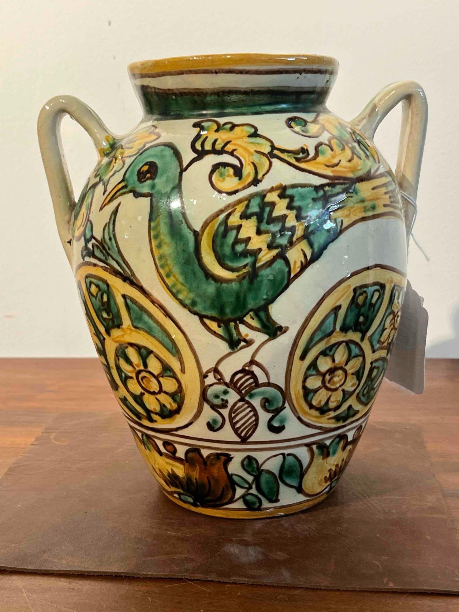 Italian Assisi Majolica Bird Vase: This Italian hand painted earthenware vase is crafted in the majolica tradition, featuring an ovoid body and two vertical strap handles attached at the rim and shoulder. The vessel is decorated in a