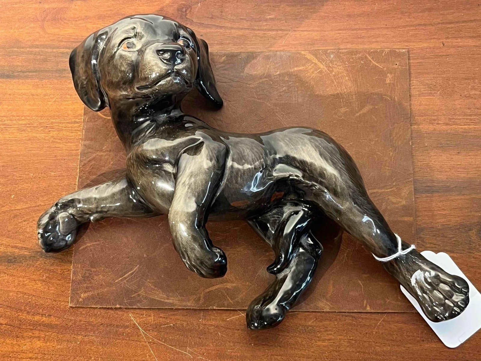 Goebel Ceramic Reclining Labrador Puppy: A West German glazed ceramic figurine depicting a reclining puppy in a playful pose. The puppy is modeled lying on its back with its head turned to one side and its limbs curled. The piece is finished