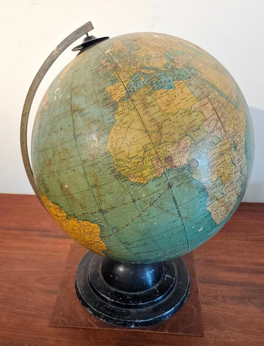 Cram's Terrestrial Globe w/ Meridian: A terrestrial desktop globe featuring printed paper gores over a composition orb. The globe is mounted within a full, degree-graduated metal meridian ring and supported by a turned, black-painted