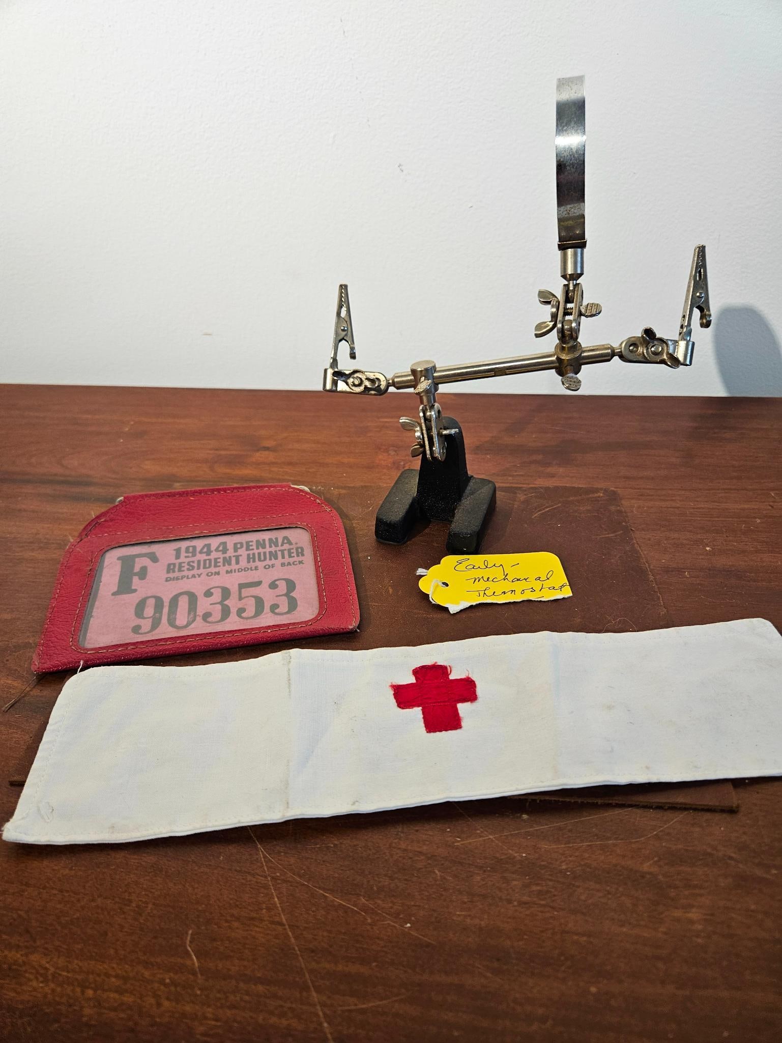 1944 PA Hunt License, Red Cross & Tool: A collection of items including a World War II era hunting license, a medical armband, and a technical workstation tool. The 1944 Pennsylvania Resident Hunter license is printed on pink cardstock