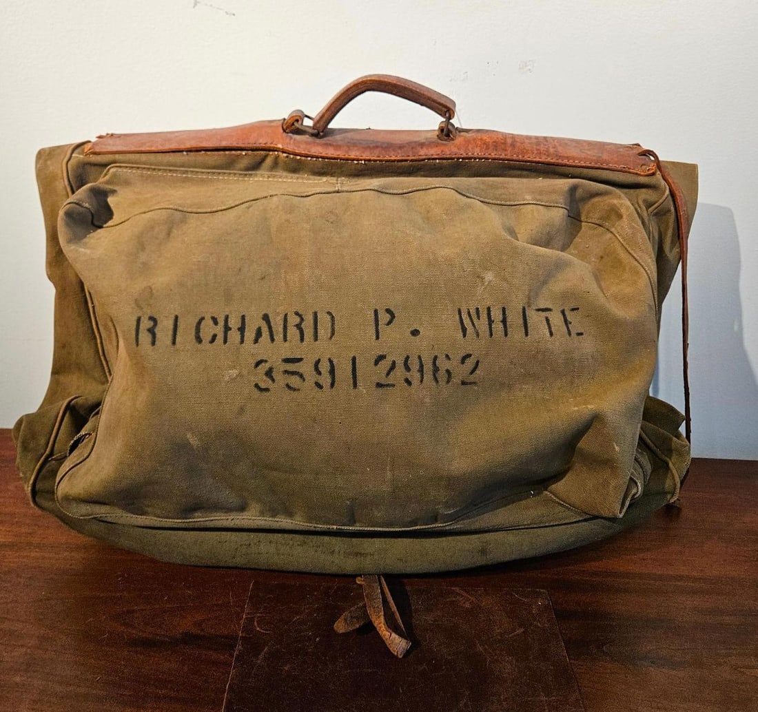 Named WWII US Army Air Forces B-4 Bag: A United States Army Air Forces B-4 traveling garment bag dating from the World War II era. The bag is constructed from heavy-weight olive drab cotton duck canvas with a rigid top frame reinforced
