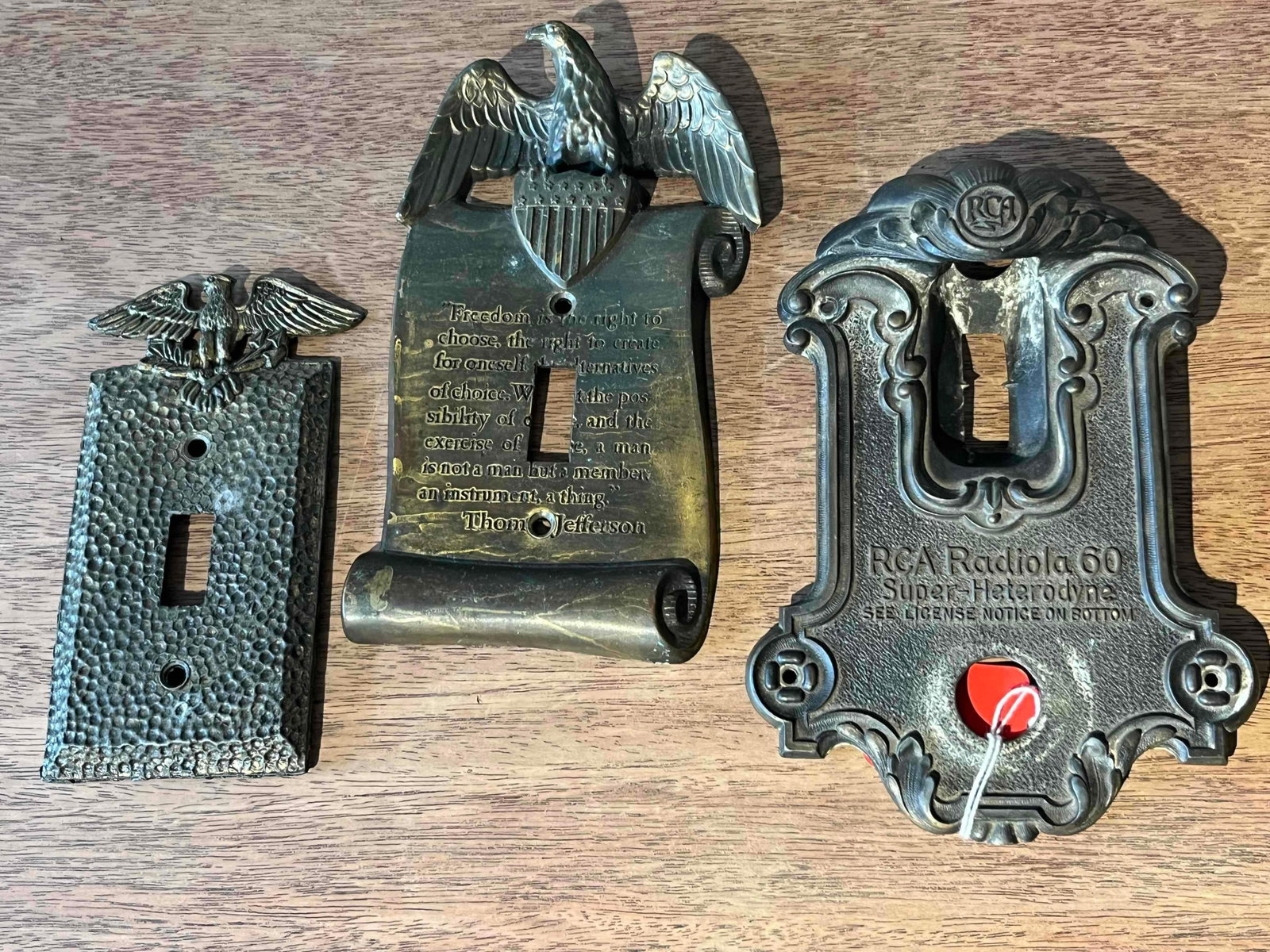 RCA Radiola 60 Escutcheon & 2 Plates: This lot comprises three cast metal decorative plates of United States origin, including one radio tuning escutcheon and two light switch covers. The radio escutcheon is a cast metal component