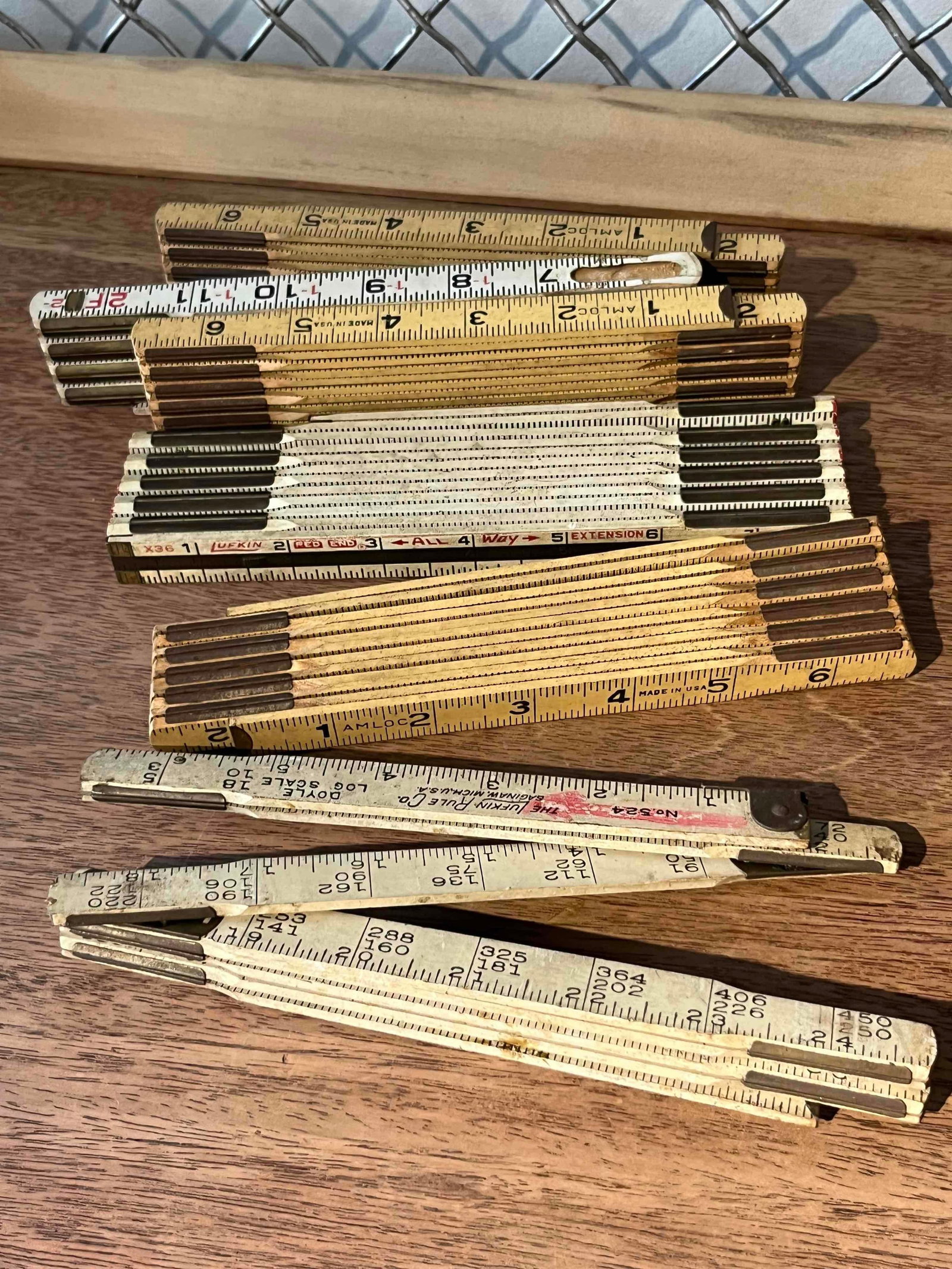 Six Lufkin & Amloc Wood Folding Rules: This lot consists of six folding carpenter's rules, also known as zig-zag rules, constructed from wood with metal hinges and end caps. The collection includes specialized measurement tools and