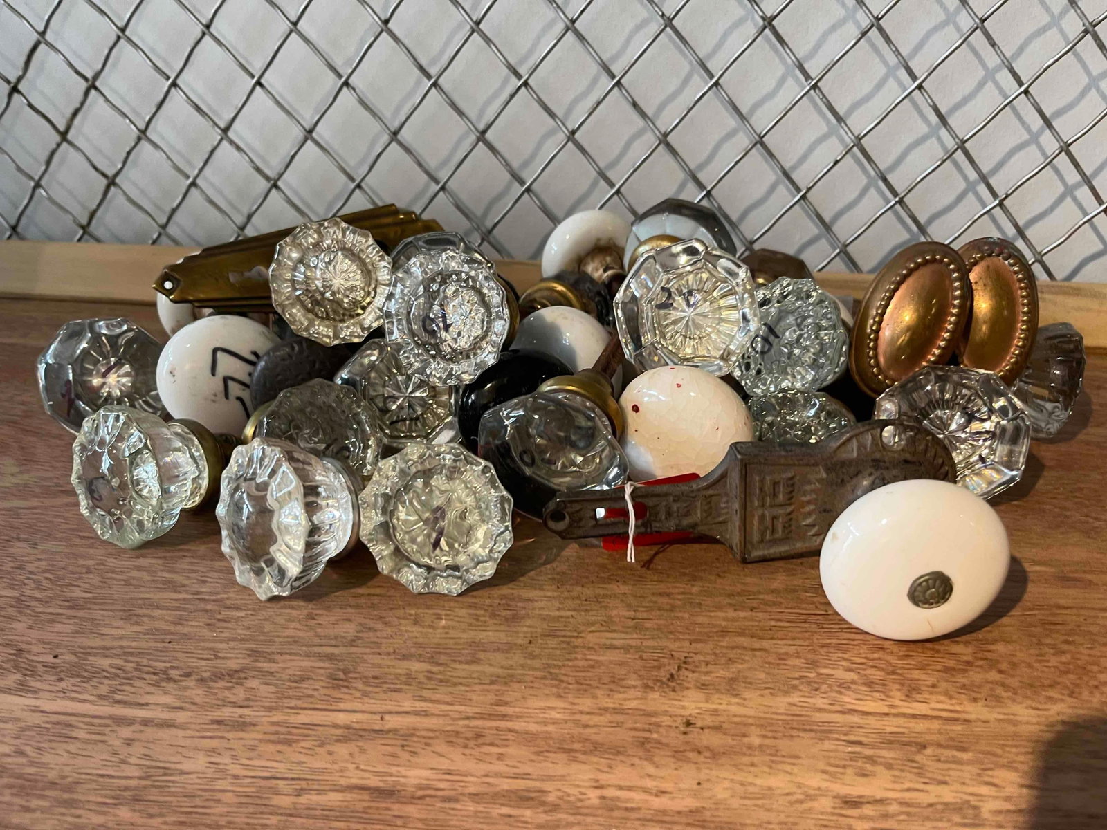 Glass & Porc. Door Hardware: A diverse lot of architectural hardware featuring faceted glass doorknobs, black and white porcelain knobs, and ornate cast metal escutcheon plates.