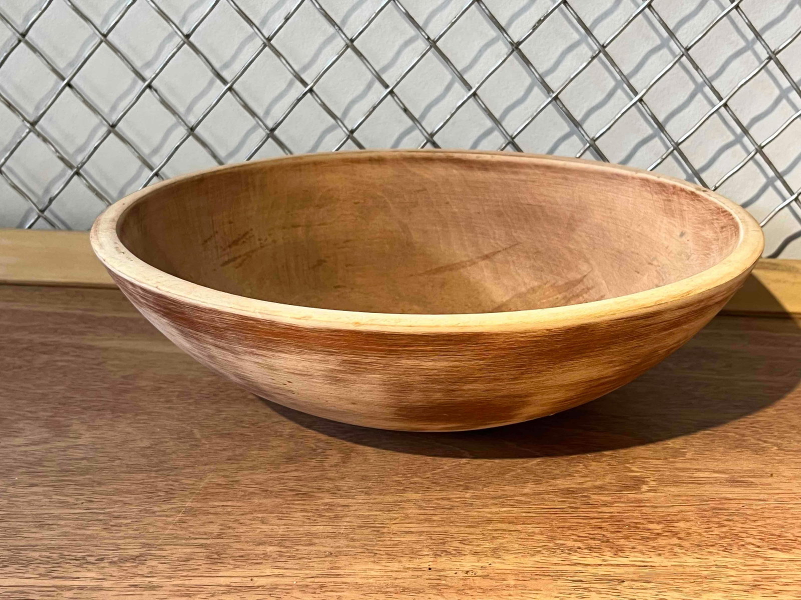 Munising Turned Maple Wood Bowl: This American turned maple wood bowl features a circular form with a wide, flared rim and a tapered base. The exterior surface is finished with a mottled reddish-brown stain, while the interior