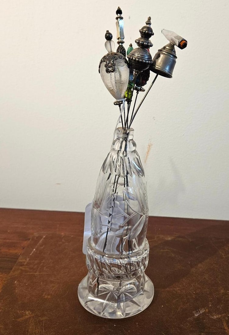 Cut Crystal Hatpin Holder & Hatpins: A footed vessel made of clear cut crystal, characterized by a tapered neck, a bulbous midsection, and a flared, heavy base. The exterior is decorated with a combination of vertical mitre cuts and fros
