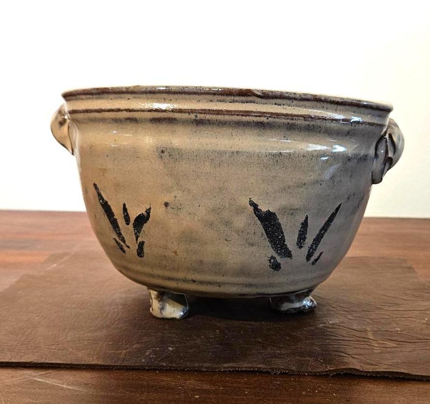 Joan Barrett Footed Stoneware Planter: A studio pottery stoneware planter featuring a rounded, slightly squared bowl form. The vessel is constructed with two small, ribbed, horizontal loop handles applied just below the rim and stands on t