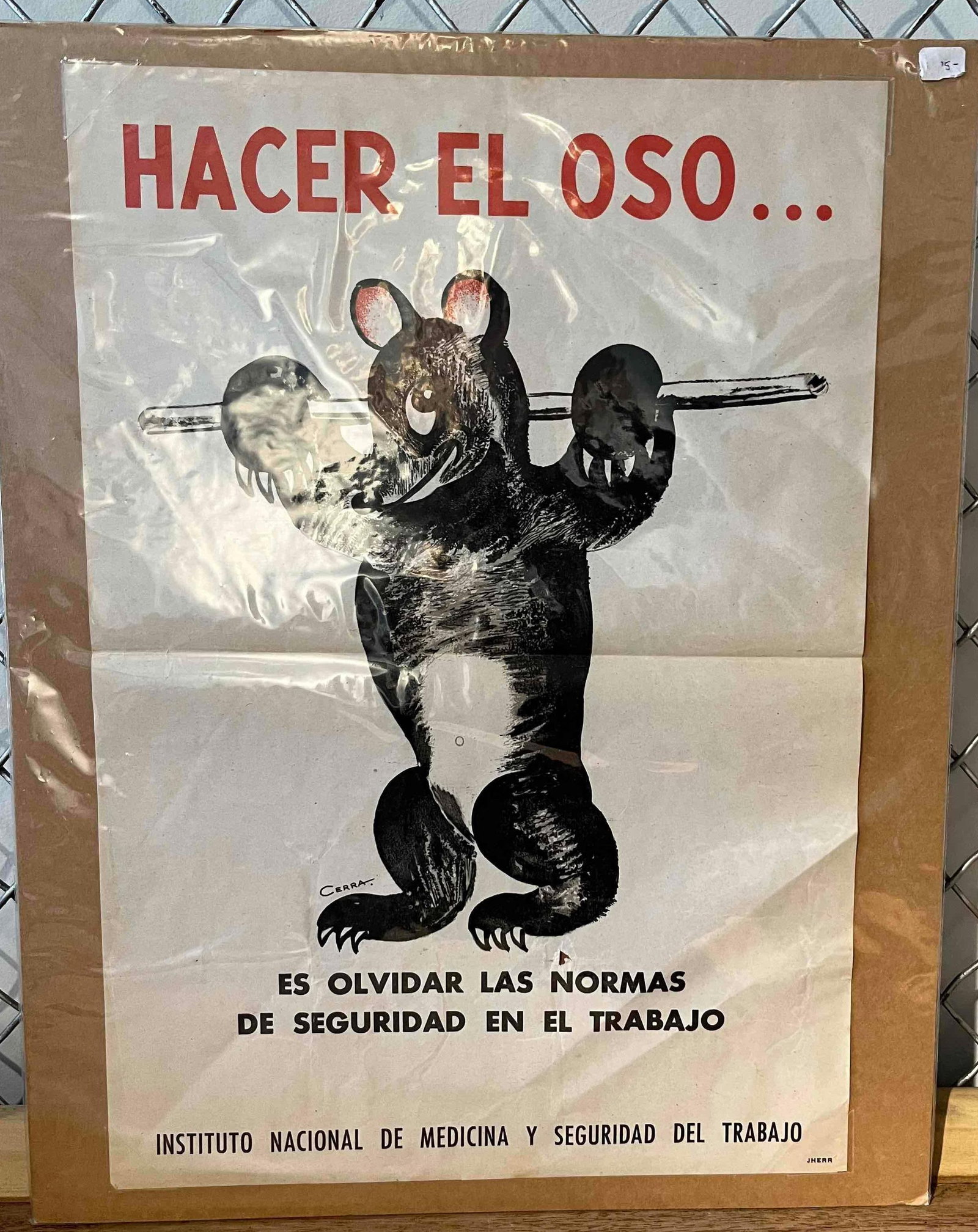 Cerra Safety Poster Hacer El Oso: A mid-century Spanish industrial safety poster printed in red and black ink on cream-colored paper. The illustration depicts a cartoonish bear struggling to balance a horizontal metal bar on its shoul