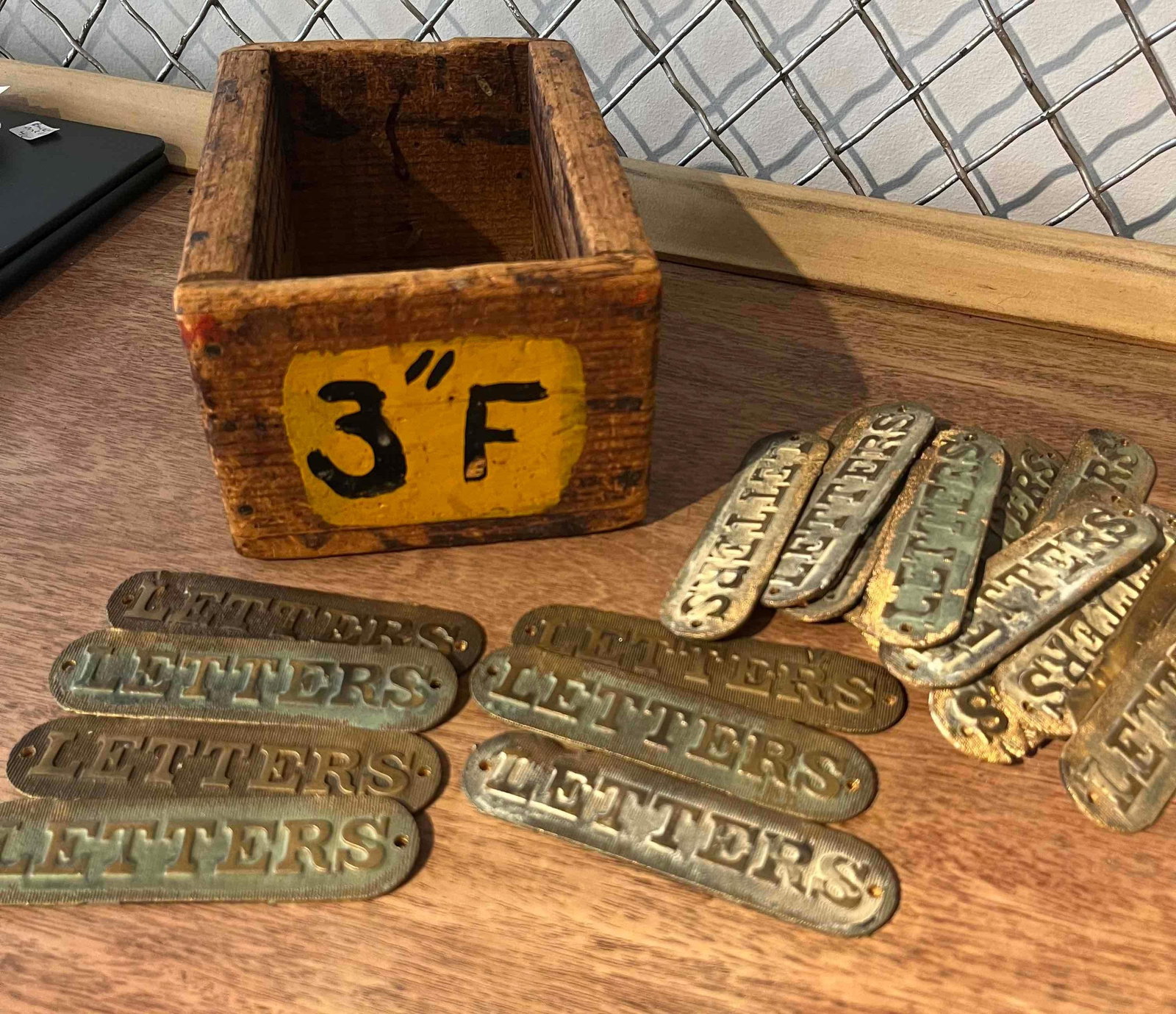 Brass Mail Slot Escutcheons w/ Wood Box: An assortment of early 20th-century American industrial mail slot plates, crafted from stamped brass or bronze. This collection of architectural hardware features matching escutcheons designed for doo