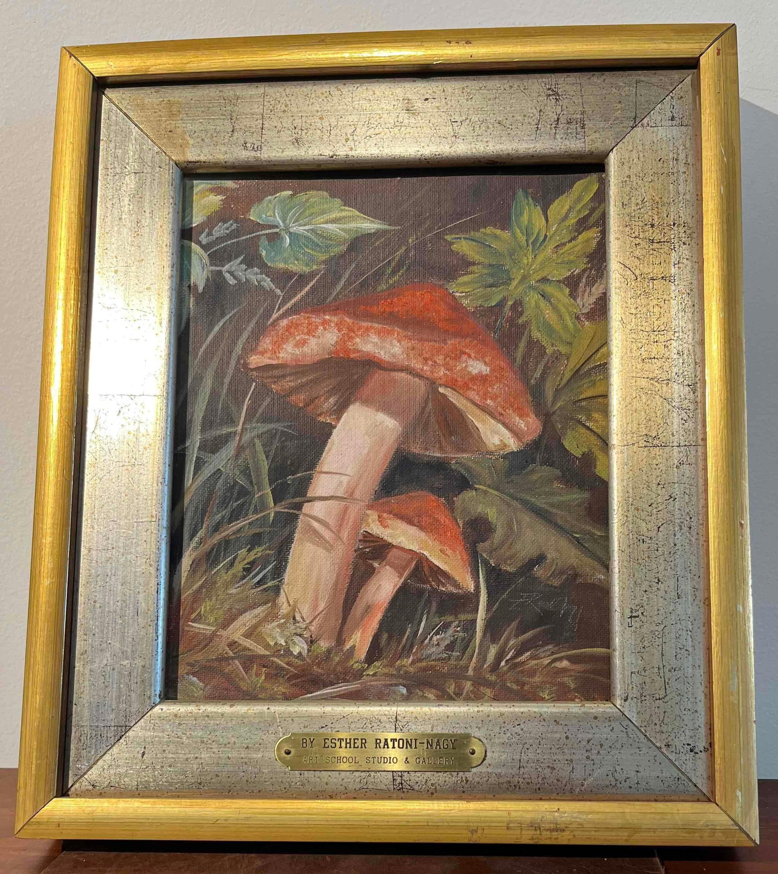E. Ratoni-Nagy Mushroom Still Life Oil: An oil on stretched canvas painting depicting a botanical still life of two mushrooms in a forest floor setting. The artwork features a large mushroom with a textured reddish-brown and ochre cap, posi