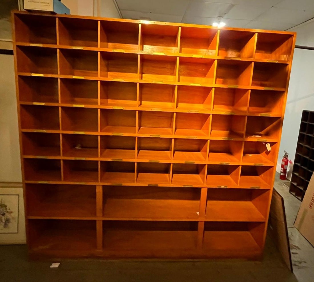 Industrial Wood Pigeonhole Cabinet: This large, utilitarian wooden sorting cabinet is designed for organizational use in mailrooms, post offices, or workshops. The unit features an upper section with 49 individual pigeonhole cubbies arr
