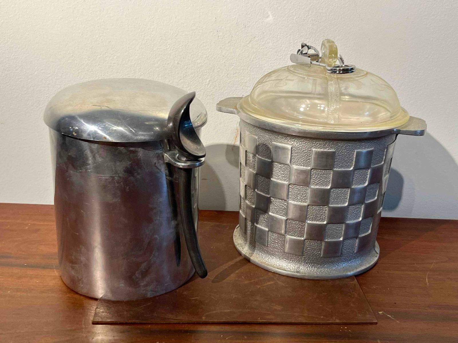 2 Mid-C. Aluminum Ice Buckets w/ Tools: This lot features two distinct ice buckets from the mid-20th century. The first ice bucket is constructed of cast aluminum with a textured pebbled ground and raised polished squares forming a checkerb