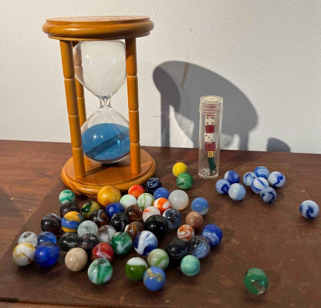 Wood Hourglass, Dice & Glass Marbles: This collection consists of various gaming items including a wooden sand timer, a set of miniature dice, and sixty glass marbles. The hourglass features a wooden frame with circular top and bottom pla