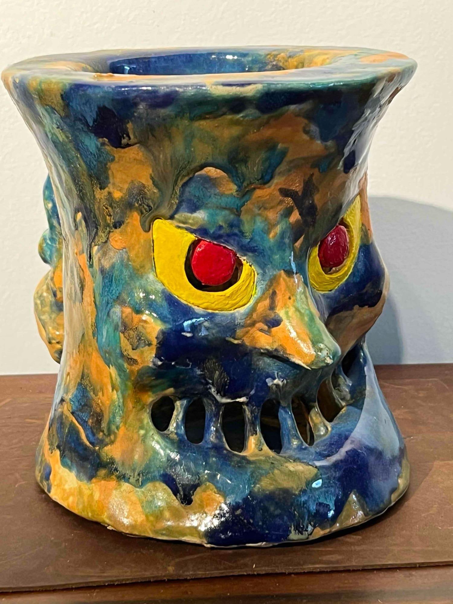 Glazed Ceramic Monster Face Vessel: A large-scale hand-sculpted ceramic art vessel featuring a stylized monstrous face. The piece is constructed from earthenware or stoneware with a flared top rim and a wide, stable base. The sculpted f