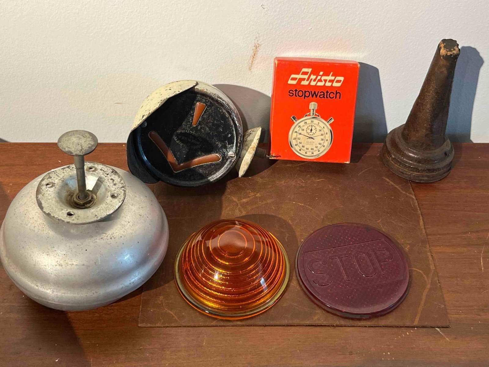 Arrow Signal Light & Apollo Stopwatch: This collection features various mechanical, industrial, and automotive items. An American-made signal light housing features an embossed circular mark on the rear reading ARROW SAFETY MADE IN U.S.A. 