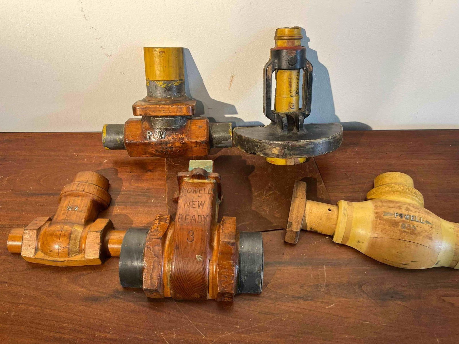 Set 5 Powell Valve Foundry Patterns: This is a group of five industrial foundry patterns for various valve components manufactured by Powell. These items are constructed of carved wood, likely pine or mahogany, and were used as master fo