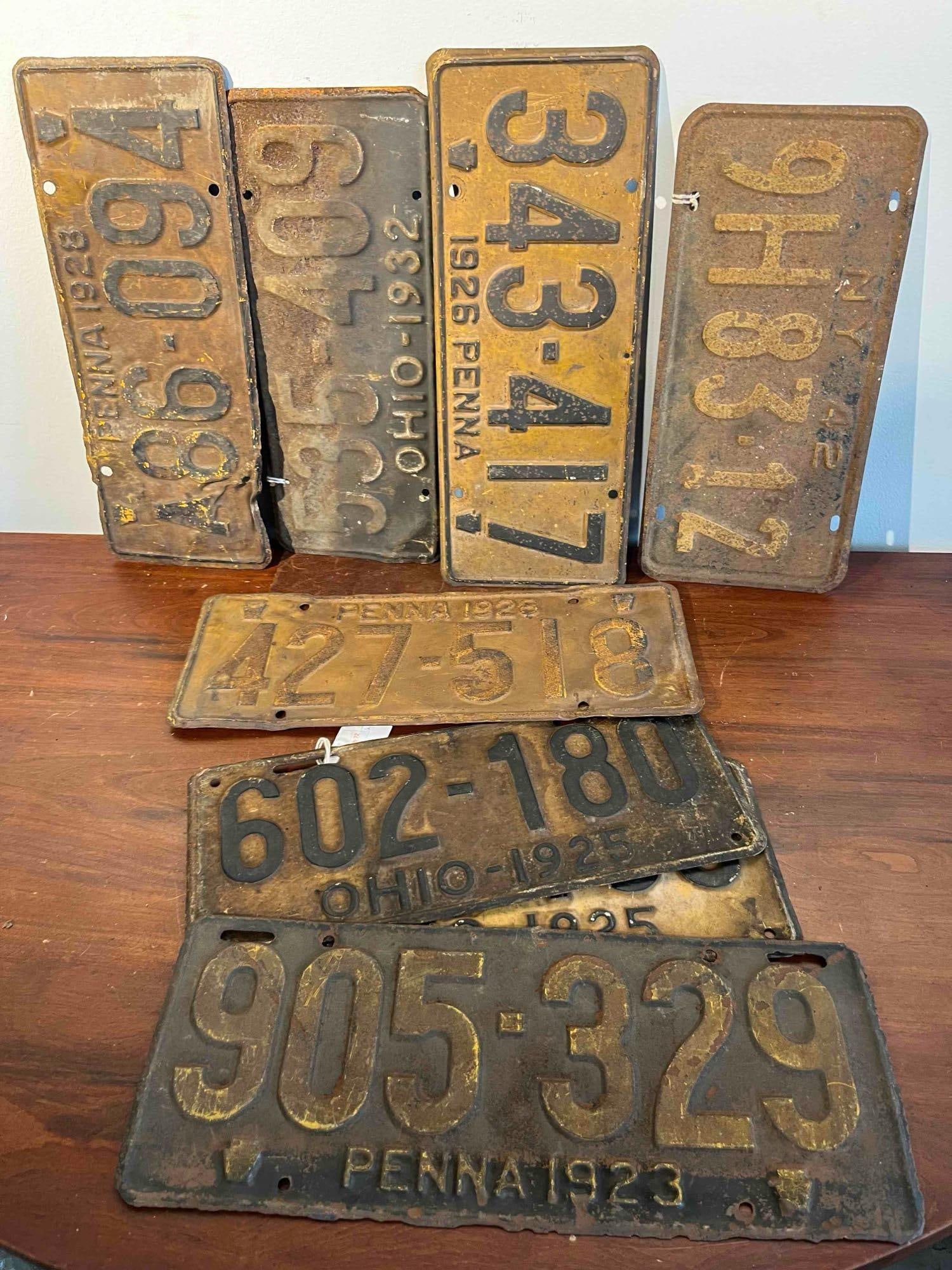 8 PA, OH & NY License Plates 1923-1942: A lot of 8 automobile license plates from the states of Pennsylvania, Ohio, and New York, dating between 1923 and 1942. The collection is constructed from embossed metal with raised borders and