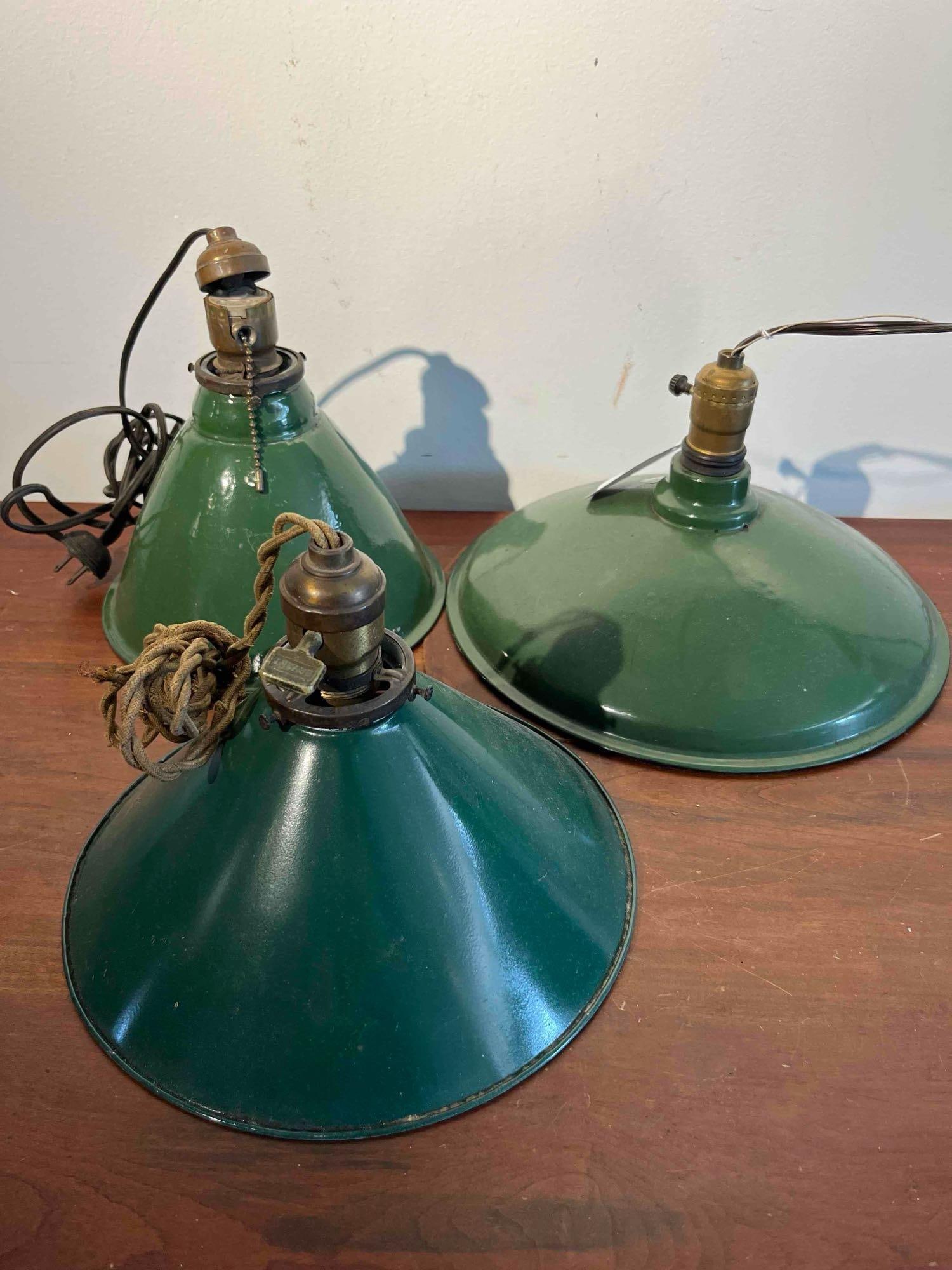 3 Bryant Green Porc. Enamel Pendants: This lot consists of three industrial pendant light fixtures of two distinct shapes: one shallow dome shade and two conical shades. The shades are constructed of steel finished with a dark forest gree
