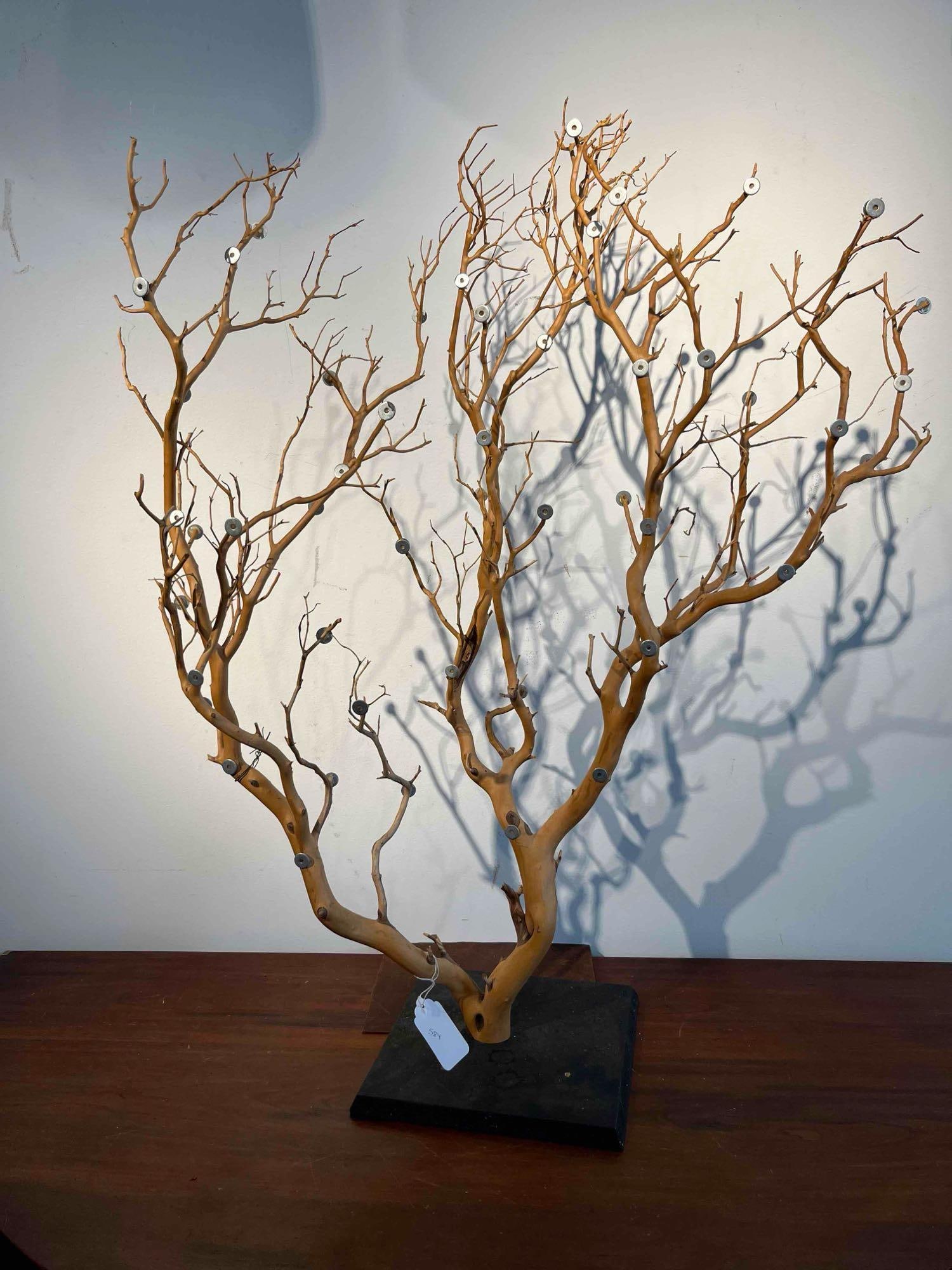Manzanita Wood Magnetic Sculpture: A contemporary mixed-media sculpture featuring naturalistic, bark-stripped manzanita wood branches mounted to a heavy, square black plinth. The sculpture incorporates approximately 30 to 40 small, cir