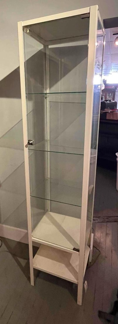 White Metal & Glass Display Cabinet: A contemporary one-piece display cabinet or vitrine constructed with a white-painted metal frame. The unit features three fixed glass side panels and a single front-opening glass door. Internally, the