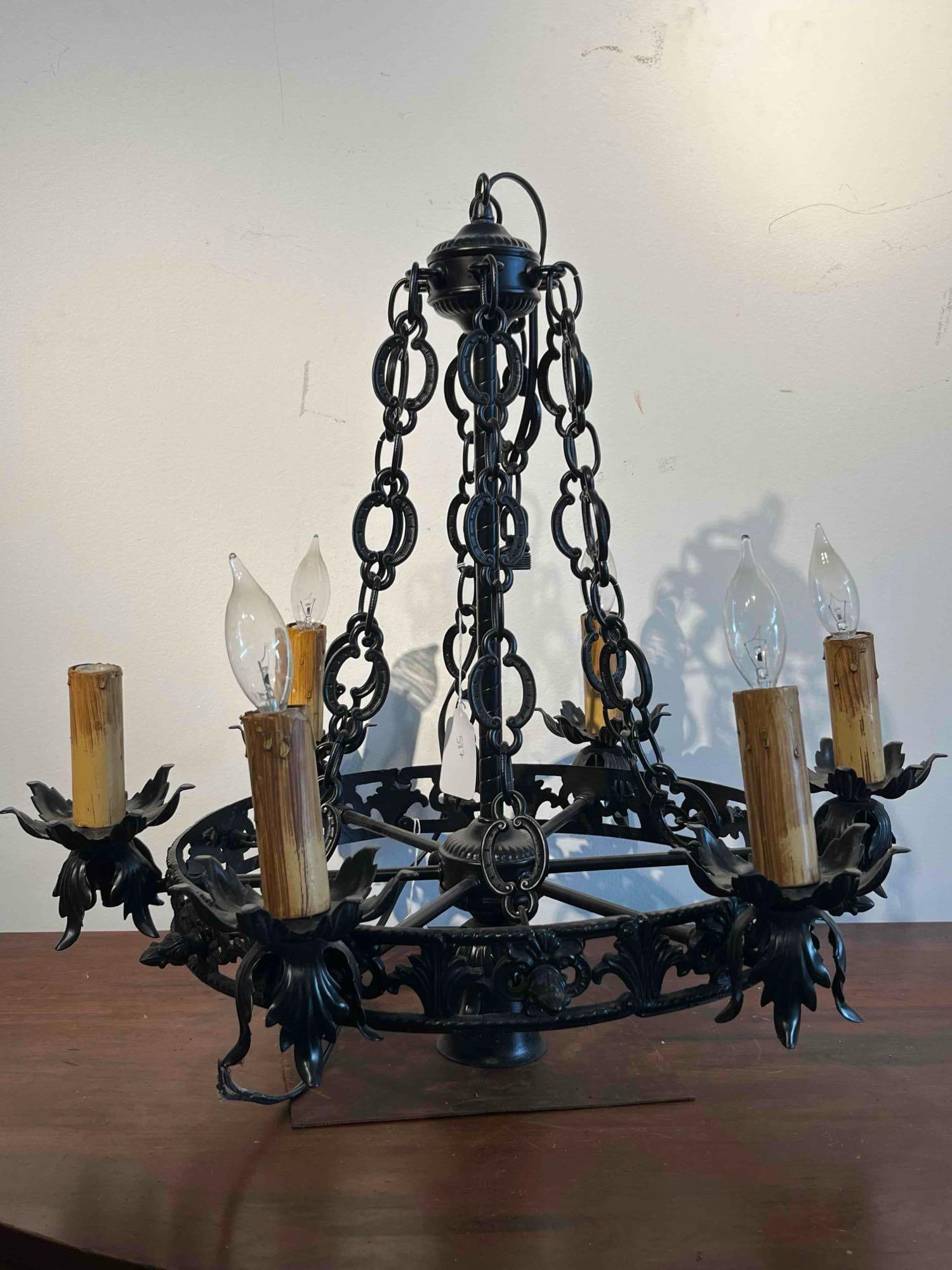 Gothic Revival Iron Ring Chandelier: A six-light wheel-form chandelier constructed from painted iron. The central ring features a repeating openwork pattern of scrolls and stylized floral motifs. Each of the six candle-base light sockets