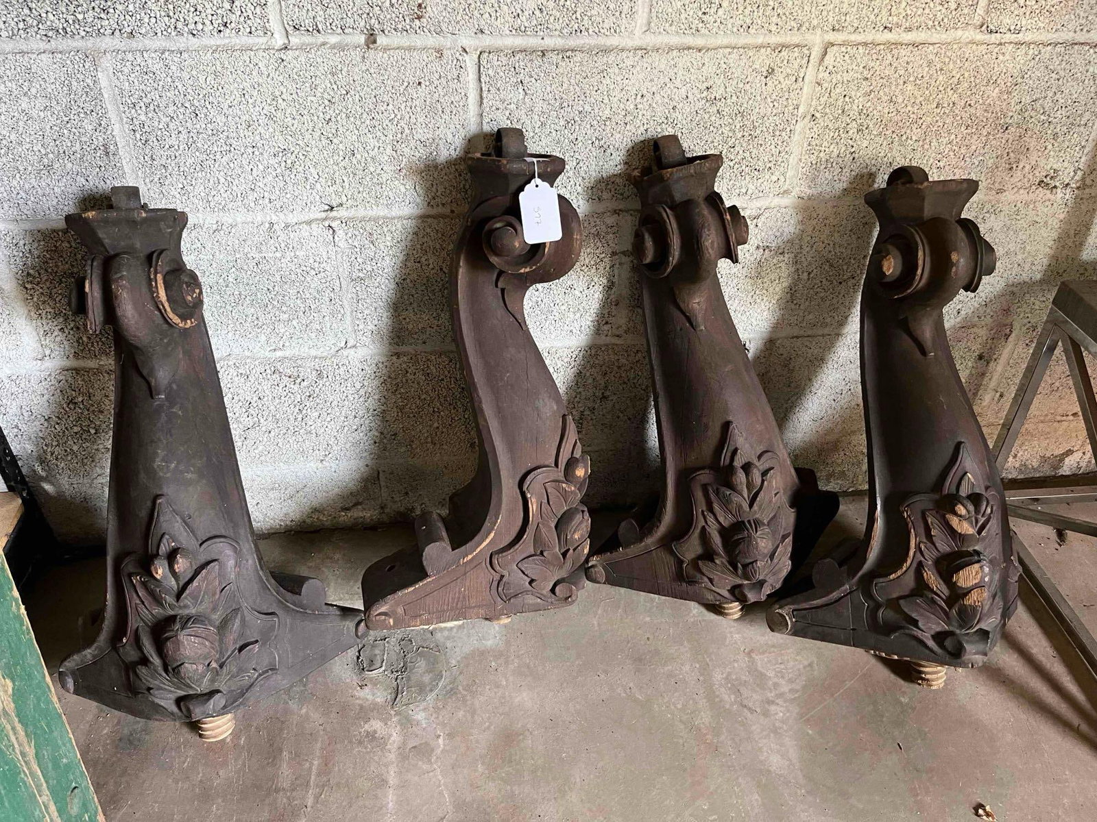 Renaissance Revival Cast Legs: A set of four architectural legs with a dark brown stain finish. Each support is designed with a deep S-curve profile, featuring a volute scroll at the top and a heavily carved decorative base. The