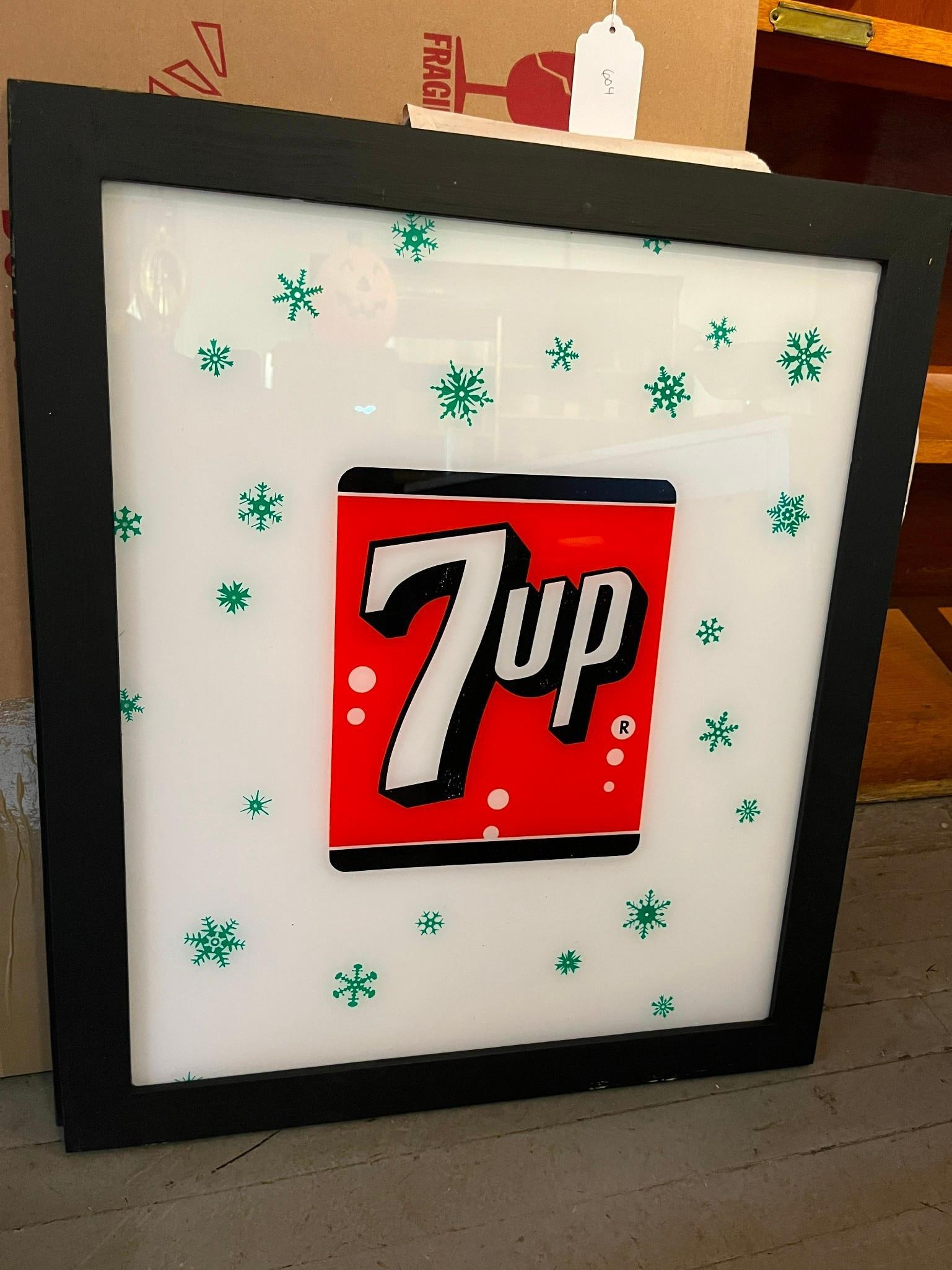 Pair Framed 7-Up Snowflake Lightboxes: This pair of advertising signs features 7-Up brand graphics, constructed as translucent white plastic panels mounted within black-finished frames. Each panel is decorated with the 7-Up logo, which