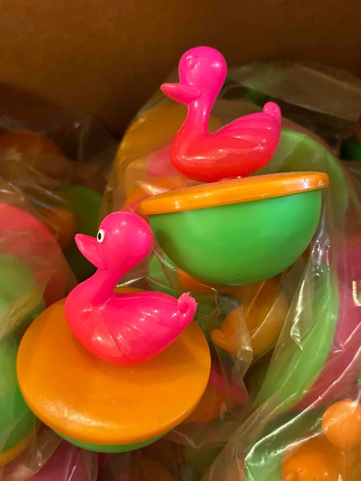 Weighted Carnival Duck Pond Toys: A large group of molded plastic floating duck toys, likely intended for use in carnival games or as bath toys. Each unit features a stylized duck figure mounted on a two-part weighted base consisting
