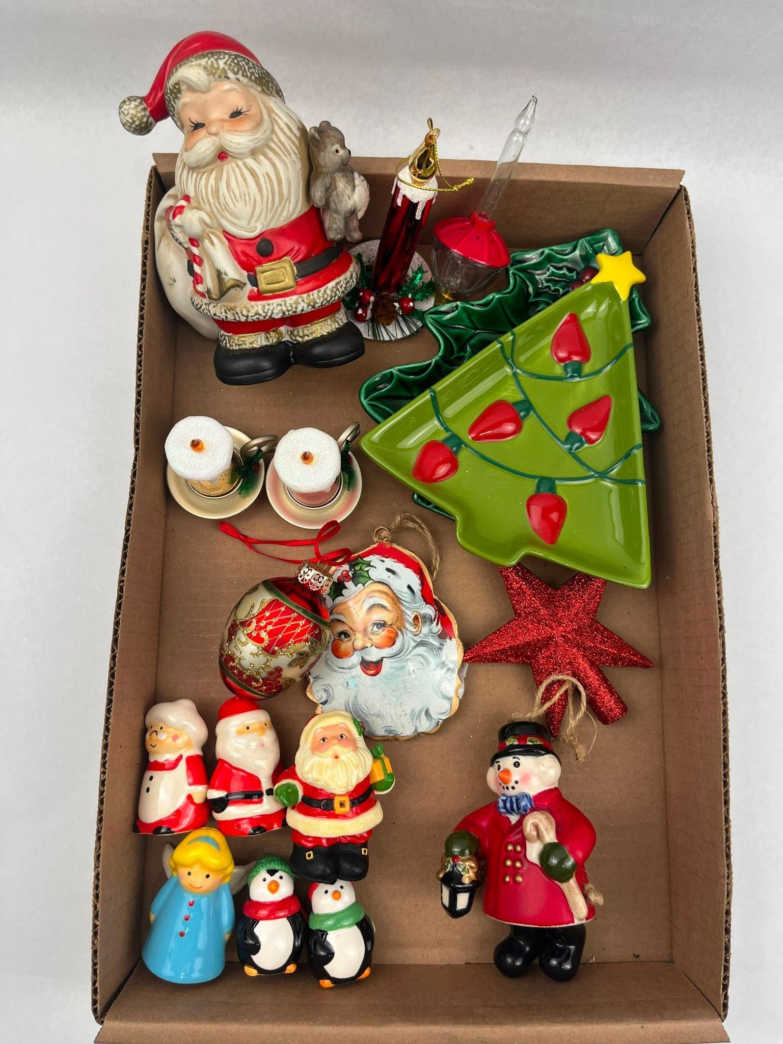 Christmas Figurines & Ornaments: A collection of Christmas decorations and figurines, primarily constructed of ceramic with mixed-material ornaments. The group includes a hand-painted ceramic Santa Claus figurine holding a brown