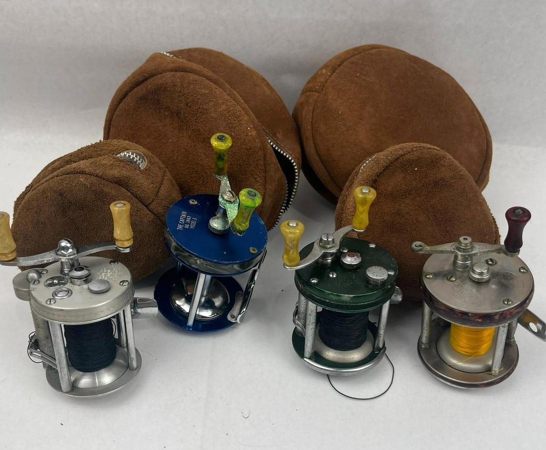 4 Pflueger & Shakespeare Baitcast Reels: A collection of four baitcasting fishing reels from prominent American tackle manufacturers, accompanied by four coordinating brown suede zippered storage pouches. The group features a silver-toned me