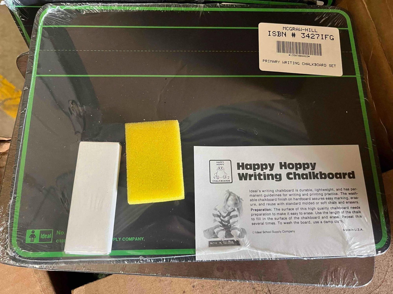 Ideal Happy Hoppy Writing Chalkboards: An assortment of American-made primary writing chalkboard sets intended for handwriting instruction. Each set features a hardboard chalkboard with a black surface and green permanent guidelines,