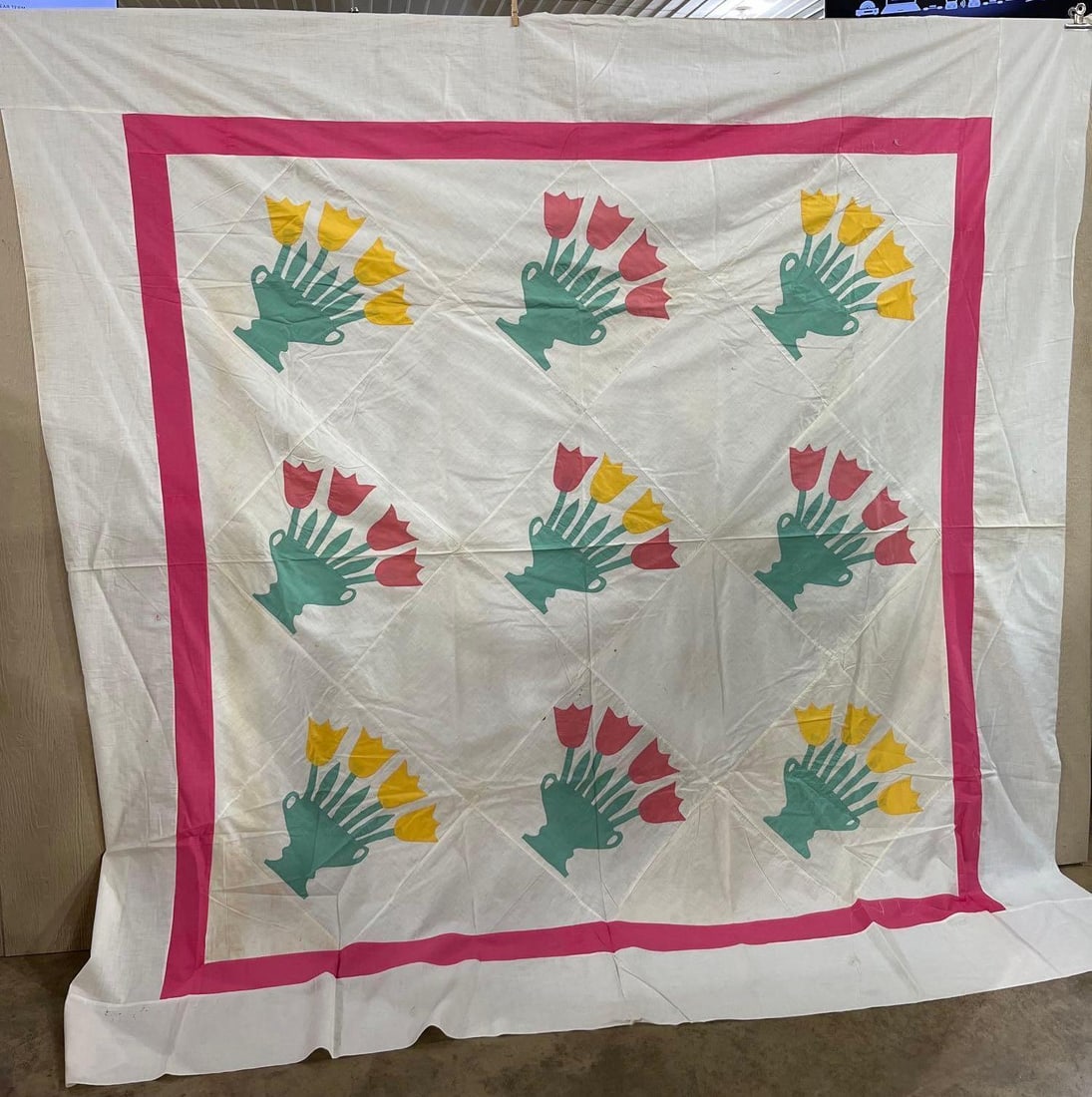 Mid-20th C. Tulip Bouquet Quilt Top: A mid-20th century quilt top crafted from fine-weave cotton. The central field consists of nine square blocks set on-point, each featuring a hand-appliqued motif of a teal-colored footed vase with two