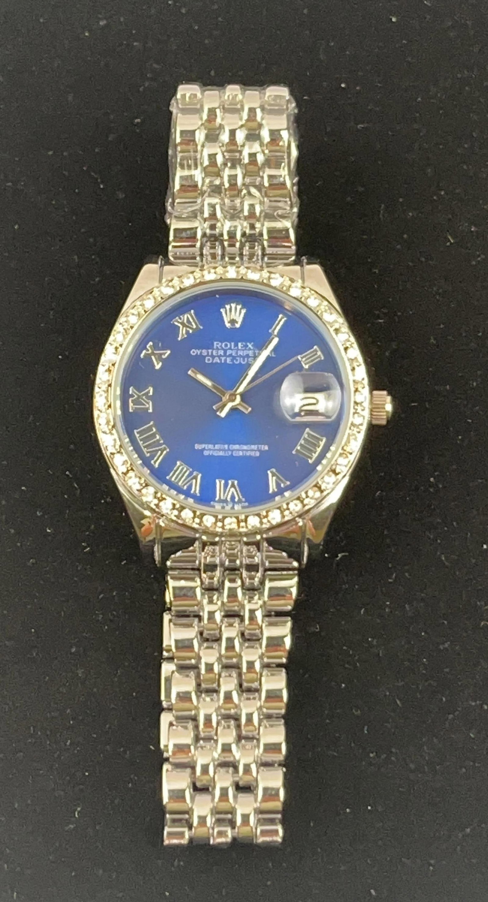 Rolex Datejust Steel Blue Roman Dial: This item has not been authenticated. A stainless steel wristwatch featuring a blue sunburst dial with applied silver-tone Roman numeral hour markers and a date aperture at the 3 o'clock position