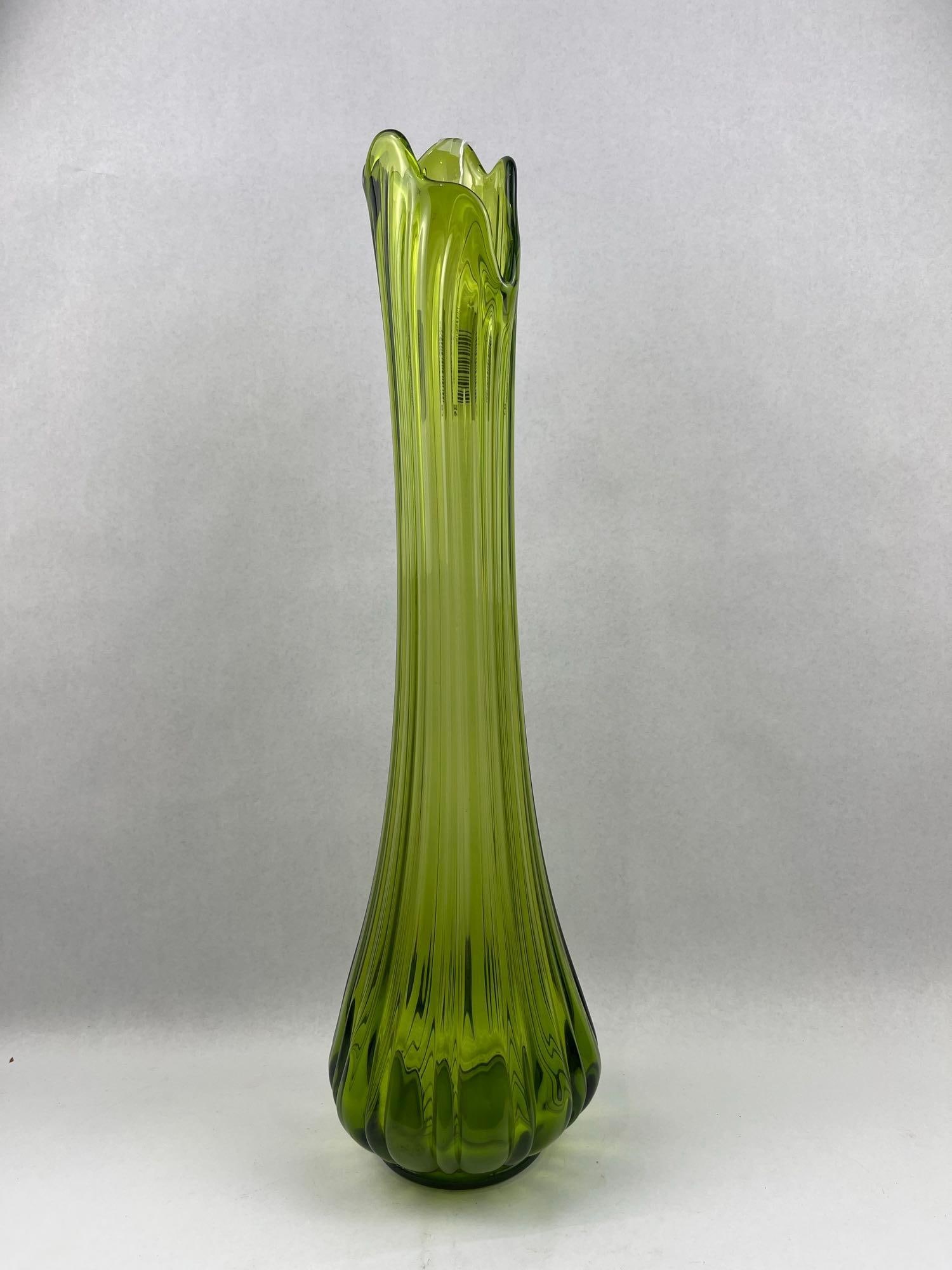Mid-C. Ribbed Swung Glass Vase, Avocado: A mid-century modern swung glass vase in avocado green. The body features molded vertical fluted ribbing that extends from the base to the mouth. No maker marks, signatures, or manufacturer labels