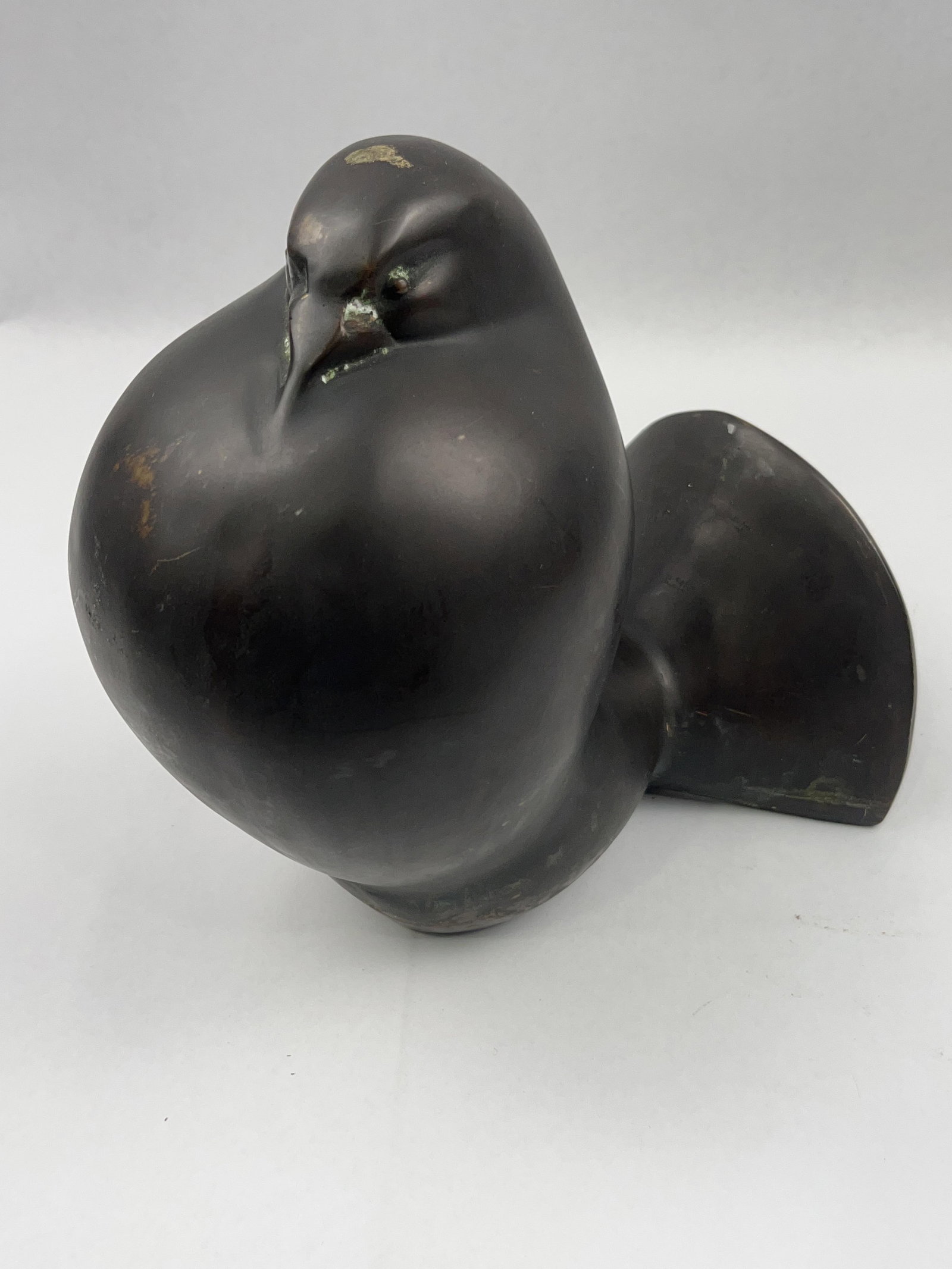 Bronze Sleeping Bird Sculpture: A modernist patinated bronze sculpture depicting a stylized resting bird, likely a pigeon or dove. Height: 8.25 inches Length: 10 inches.